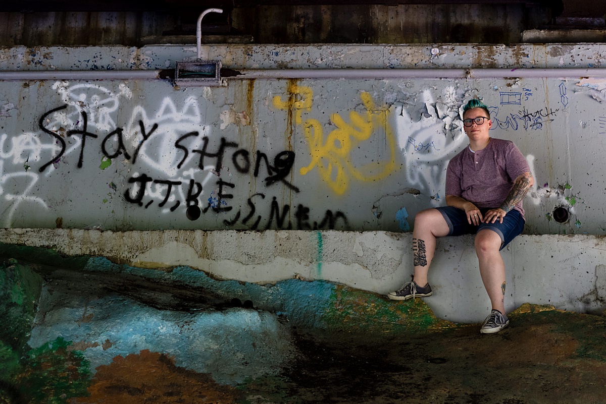 At a portrait session in downtown Dover NH she sits by graffiti reminding us all to stay strong