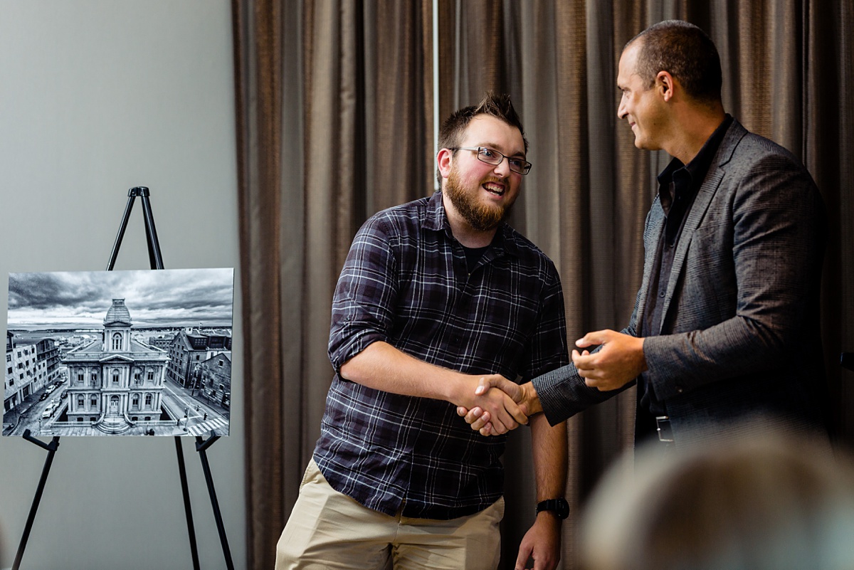 The winner of the AC Hotel Portland Maine photo contest shakes hands with Nigel Barker