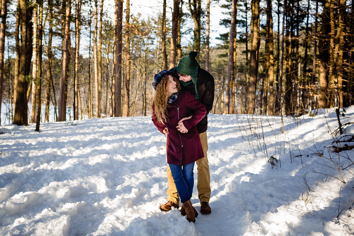 The newly engaged couple have their engagement session in the winter at snowy Fells Reservation MA by Maine Wedding Photographer Sarah V