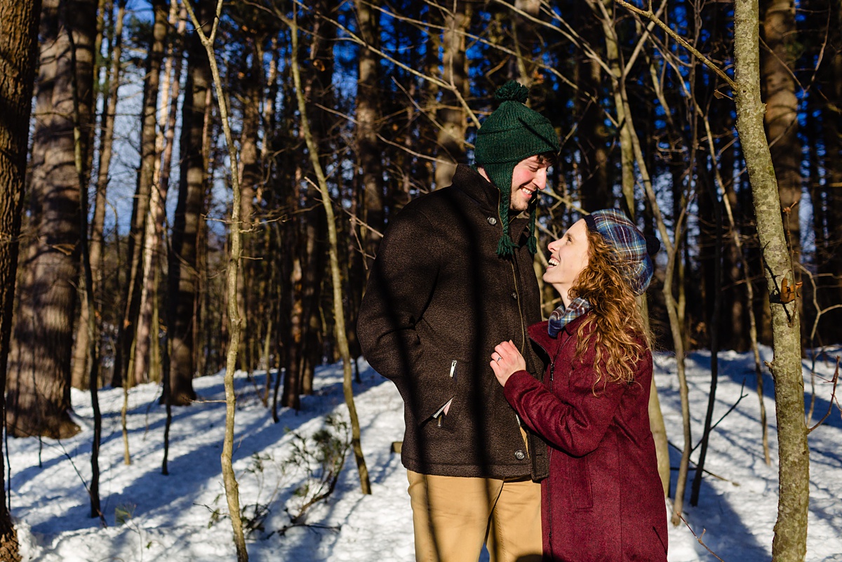 Bright sun for the winter engagement session where the couple look at each other and smile