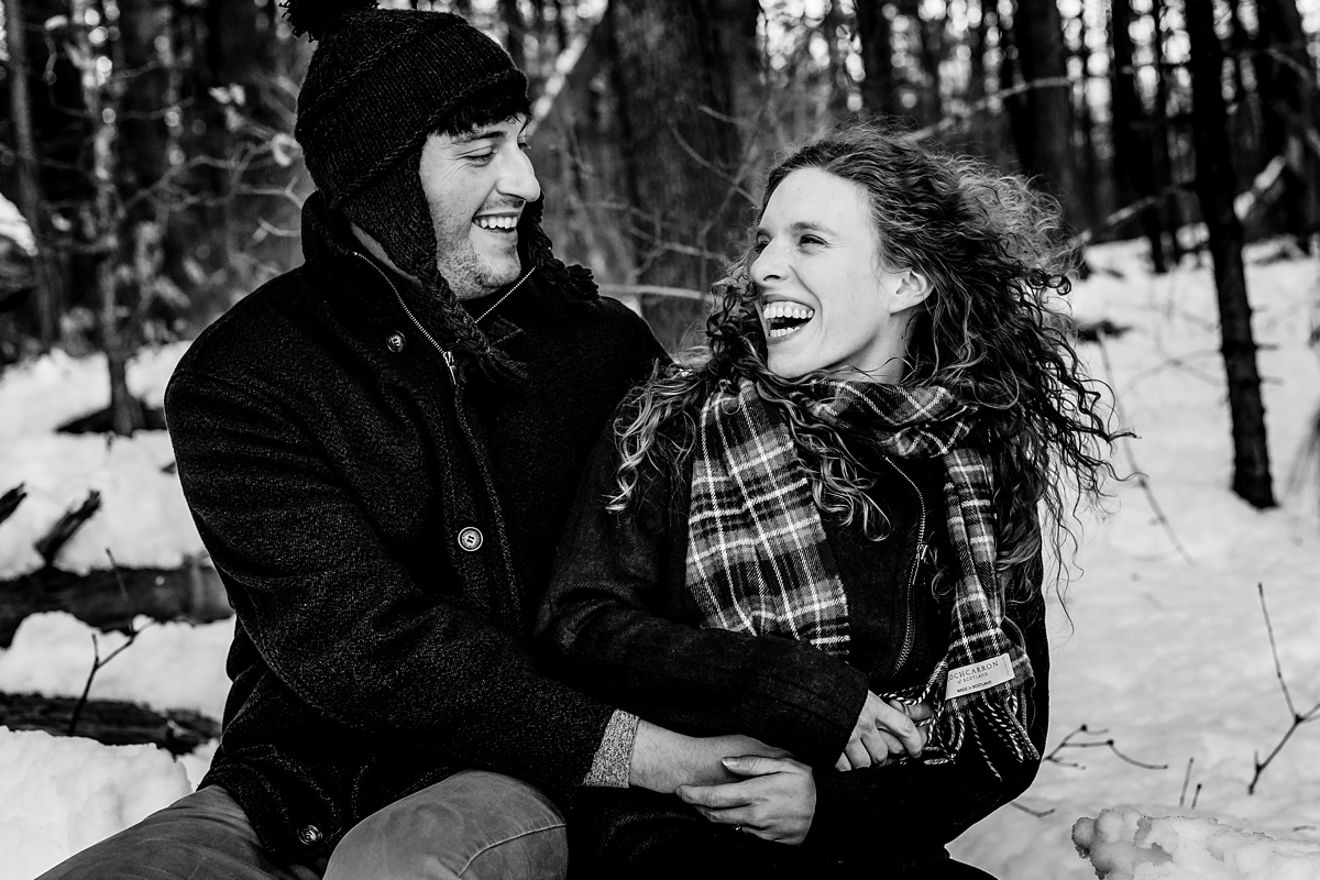 Laughter as the couple has fun at their snow filled winter engagement session in Fells Reservation MA with their Maine Wedding Photographer