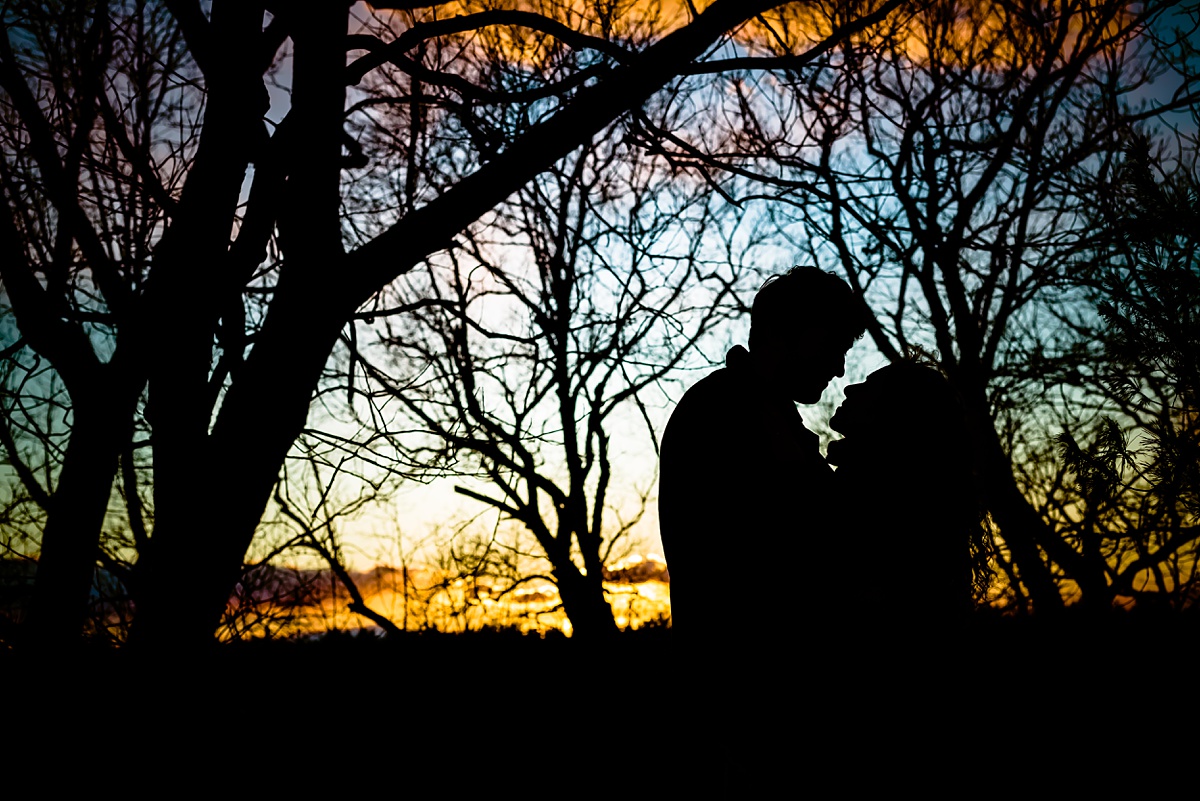 Bright winter sunset at Fells Reservation MA during the engagement session in the woods