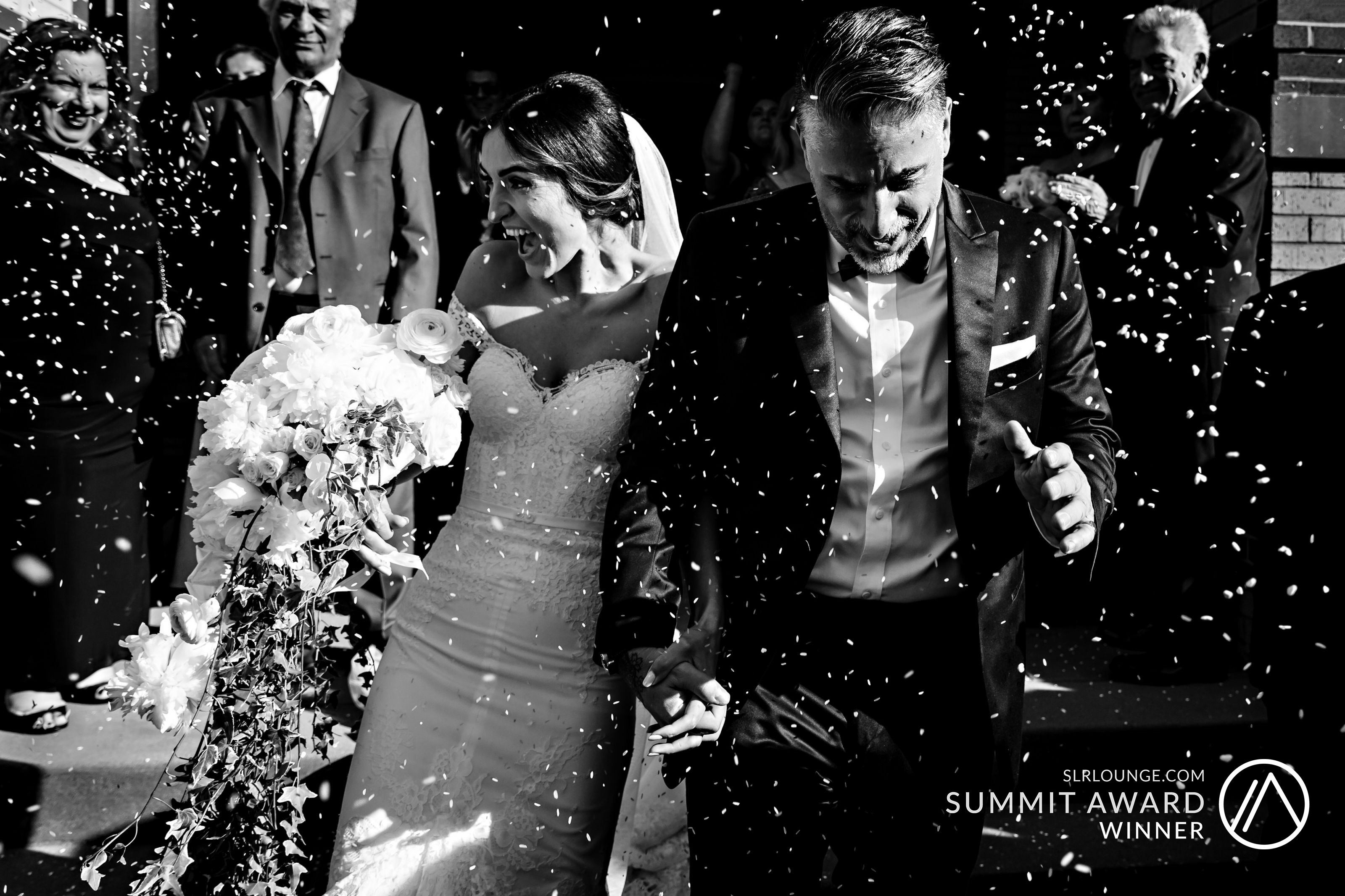 Award winning image from Maine Wedding Photographer I AM SARAH V for this image of the newlyweds exiting their Greek Orthodox ceremony under a sea of falling rice