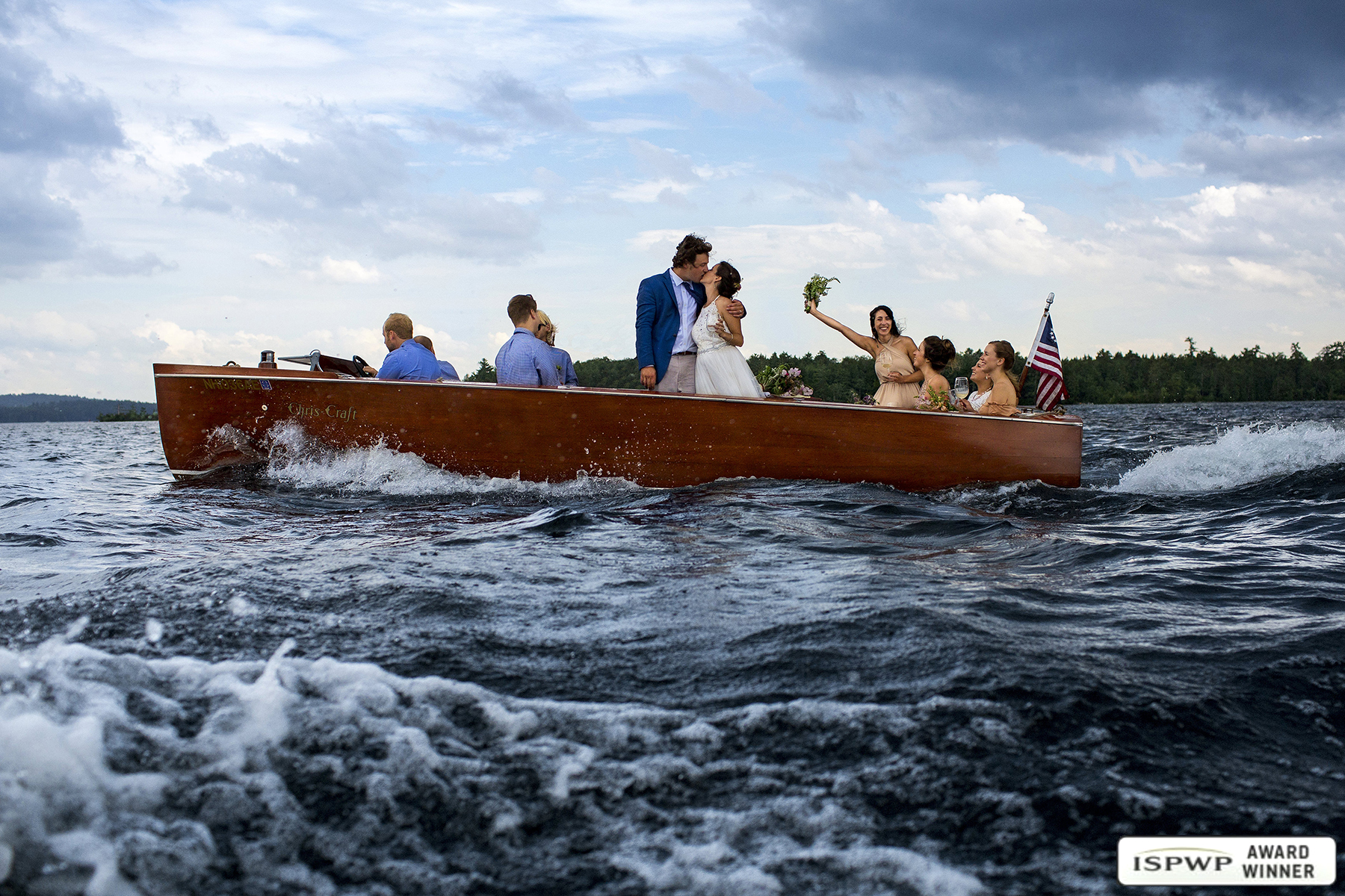 Squam Lake NH Wedding Photographer wins another award in ISPWP for the epic stormy Chris Craft boat photo of the wedding party