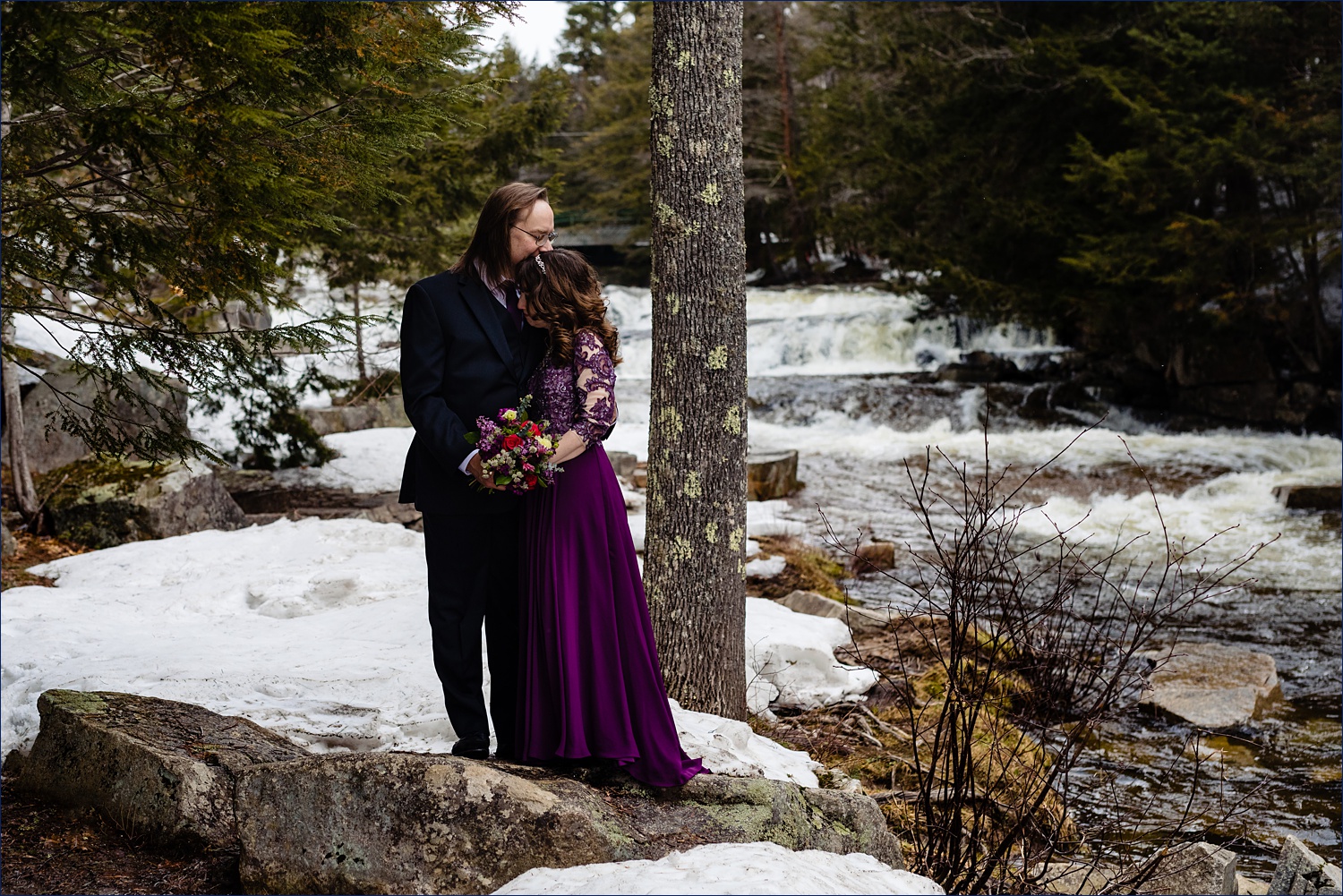The newlyweds stand by Jackson Falls in the Spring chill air after their NH Elopement