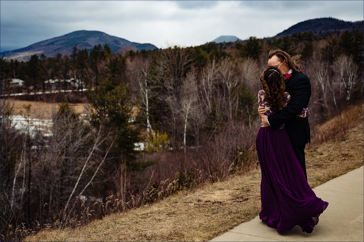 The bride and groom steal a kiss in front of the White Mountains in Jackson, NH after their elopement