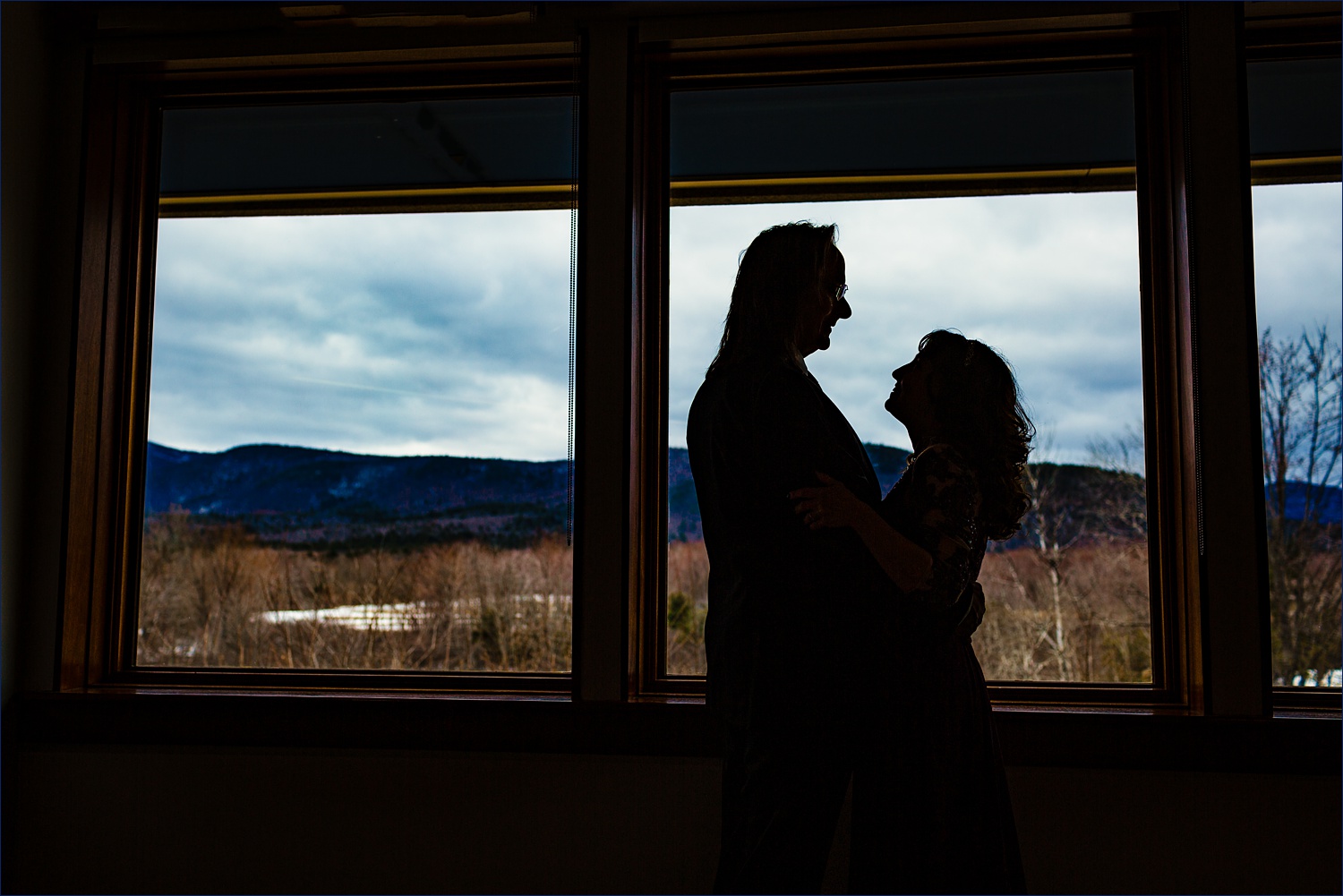 A silhouette of the newly married couple with the White Mountain range behind them