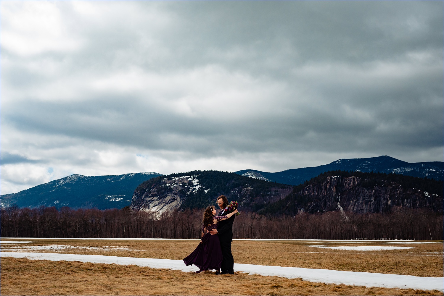The bride and groom dance in front of the White Mountains after their New Hampshire elopement in Jackson
