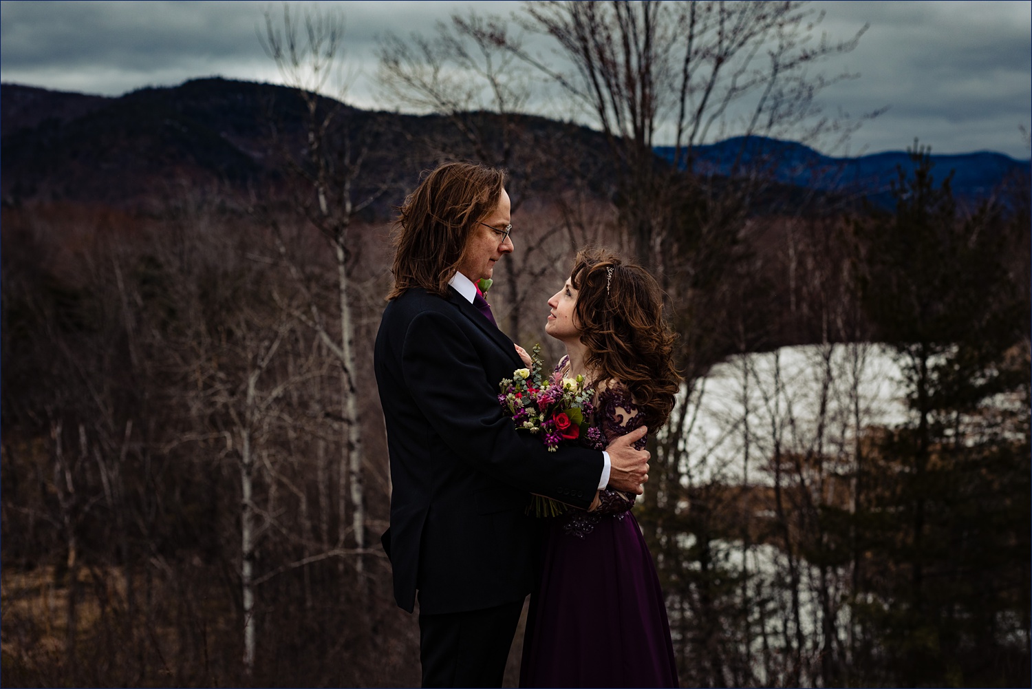 The newlyweds stand against a view of the White Mountains after their New Hampshire elopement in the Spring