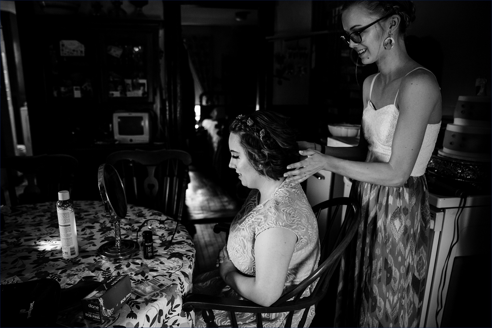 The bride has her hair finalized by her friend in the family's Maine farmhouse before the wedding starts