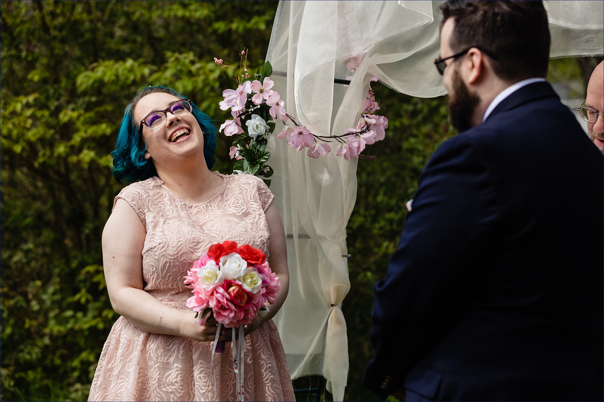 The bride laughs during their outdoor intimate Maine wedding in the backyard