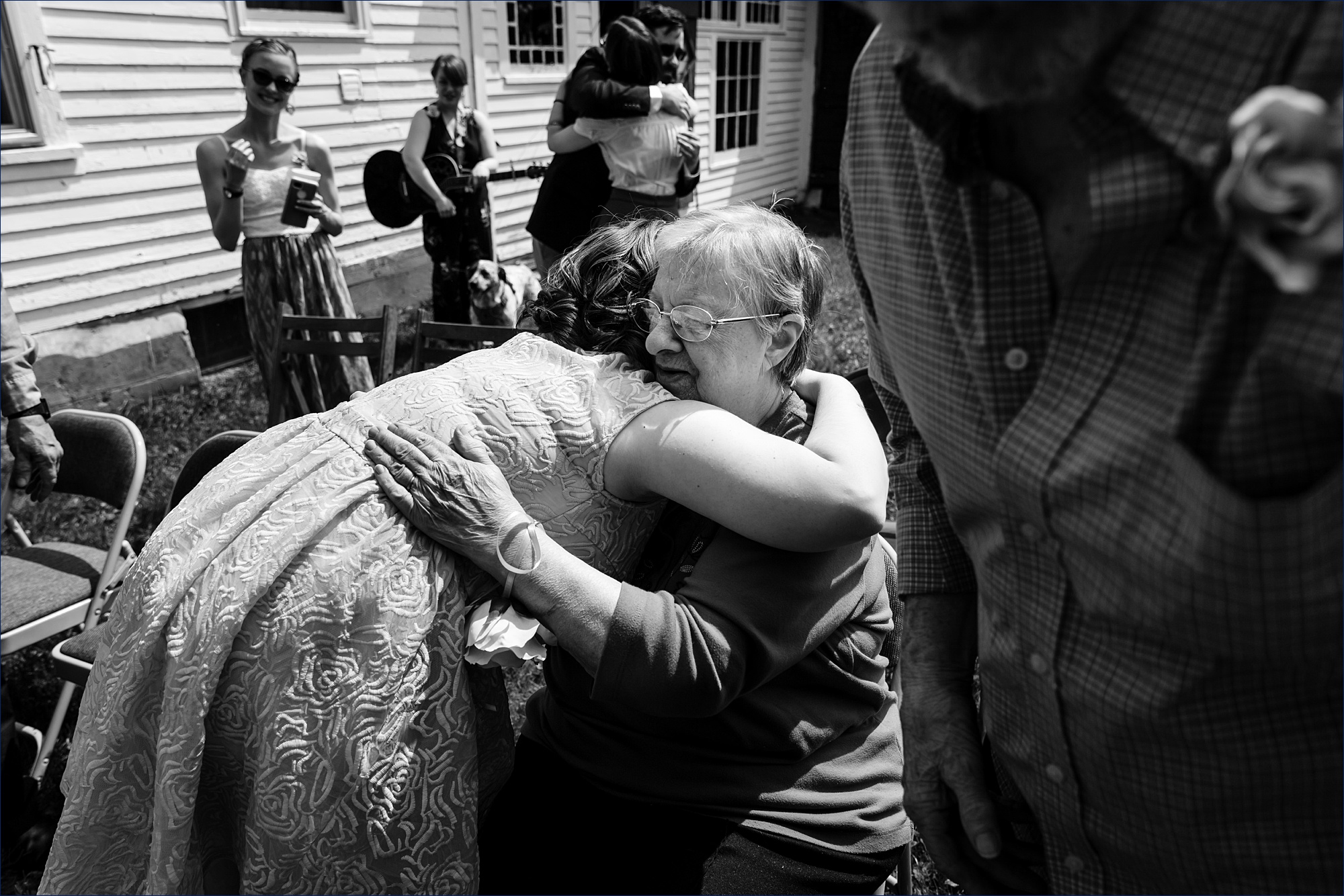 The bride hugs her new grandmother after the ceremony on her Maine farmhouse's backyard