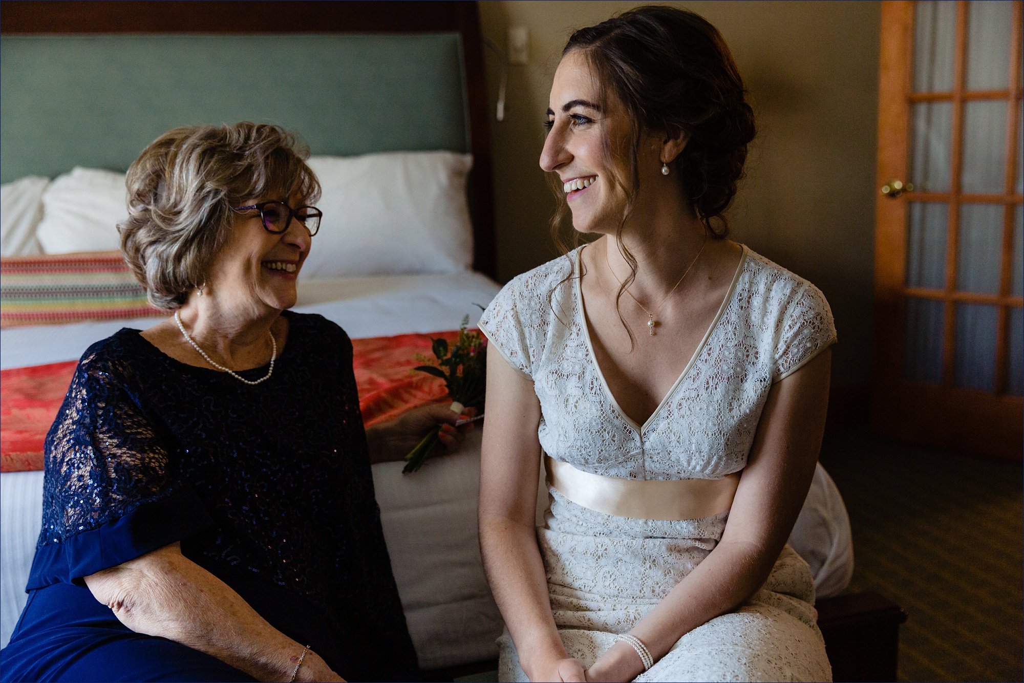 The bride shares a laugh with her mom on her intimate wedding day celebration