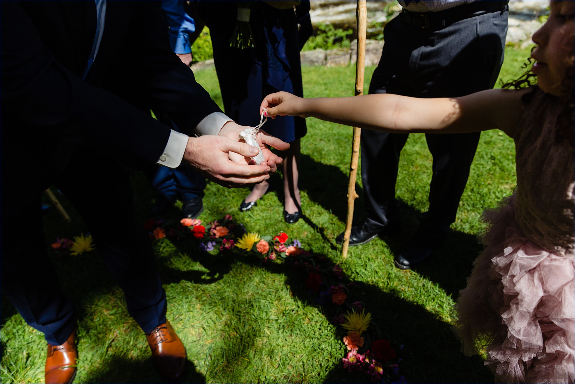 The niece of the bride hands the groom the rings for the New Hampshire elopement ceremony on a sunny day