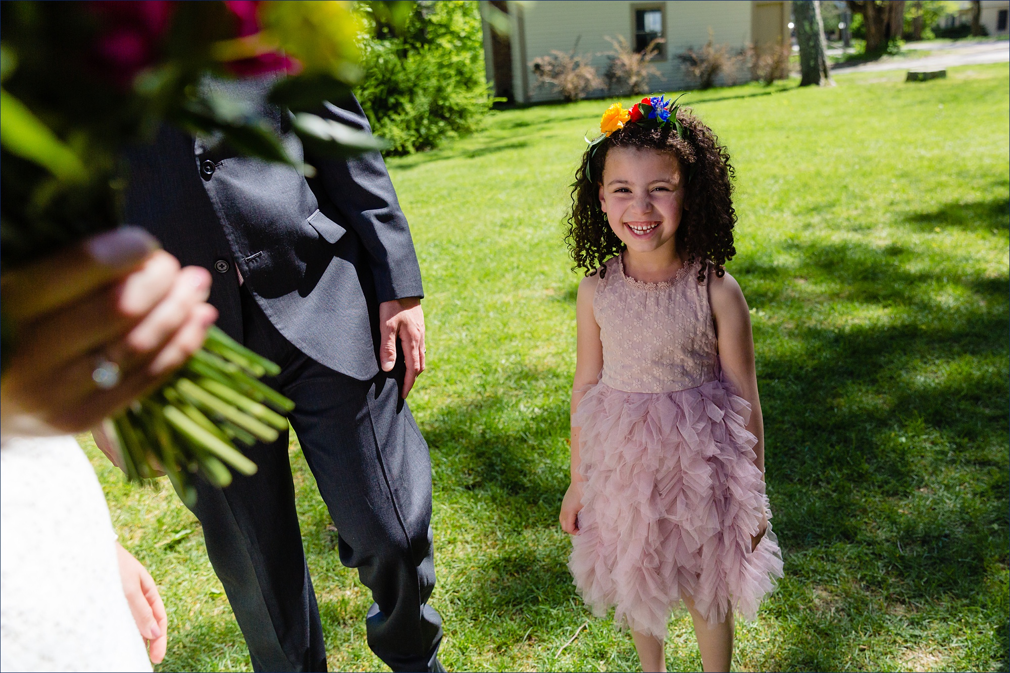 The flower girl smiles big after the outdoor wedding ceremony
