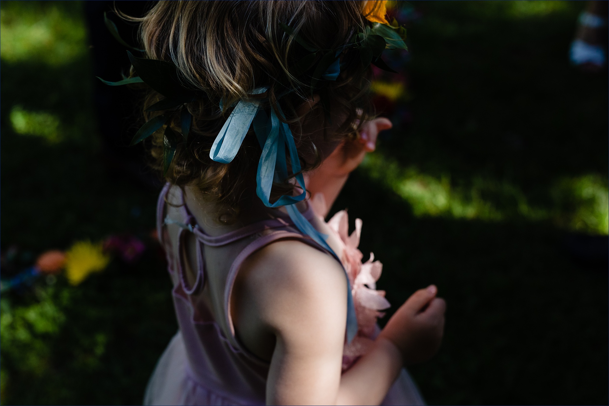 The flower girl's ribbons in the bright sun of her aunt's wedding day