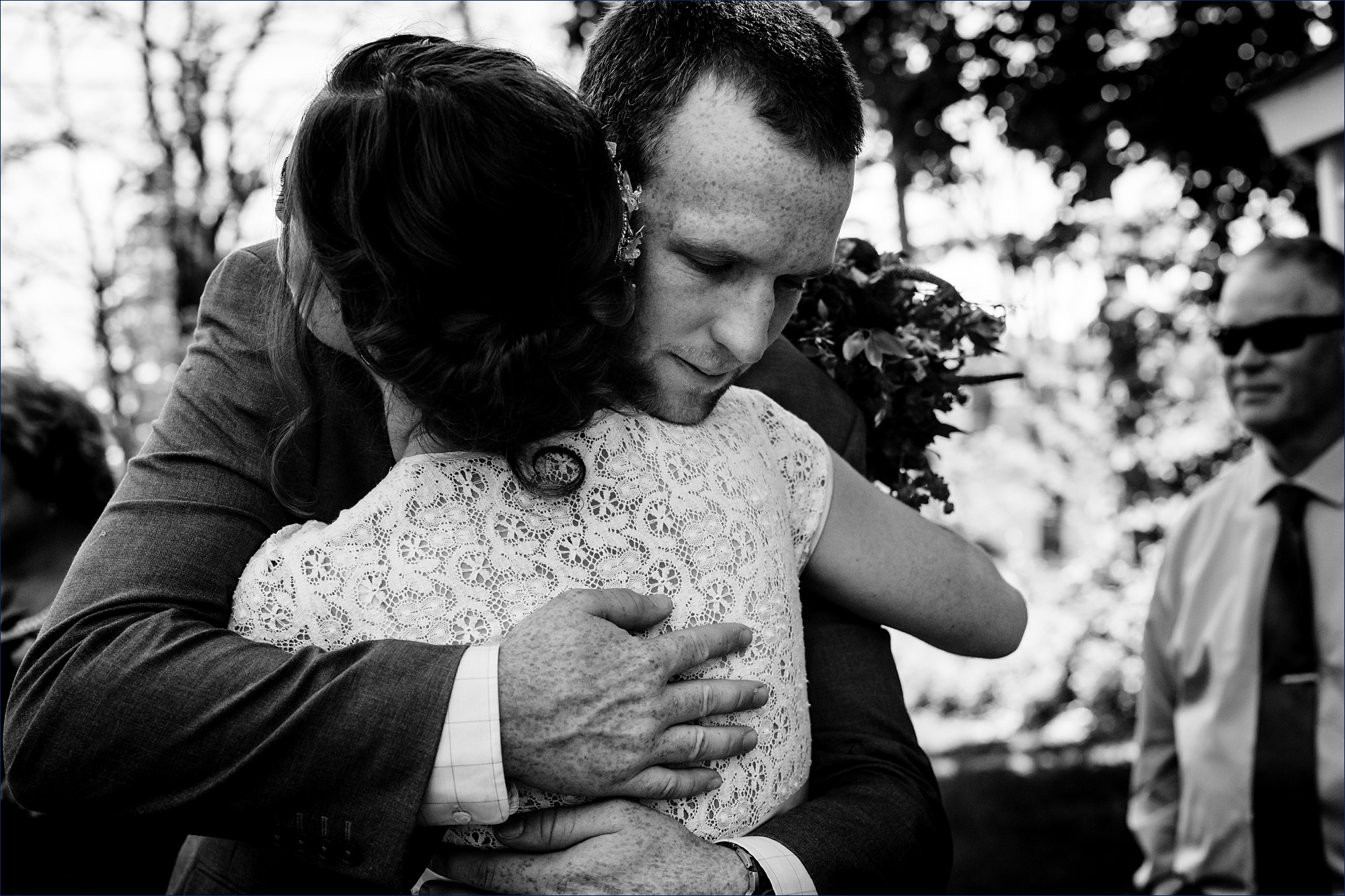 The bride lovingly hugs her brother after her outdoor NH wedding ceremony in Jackson