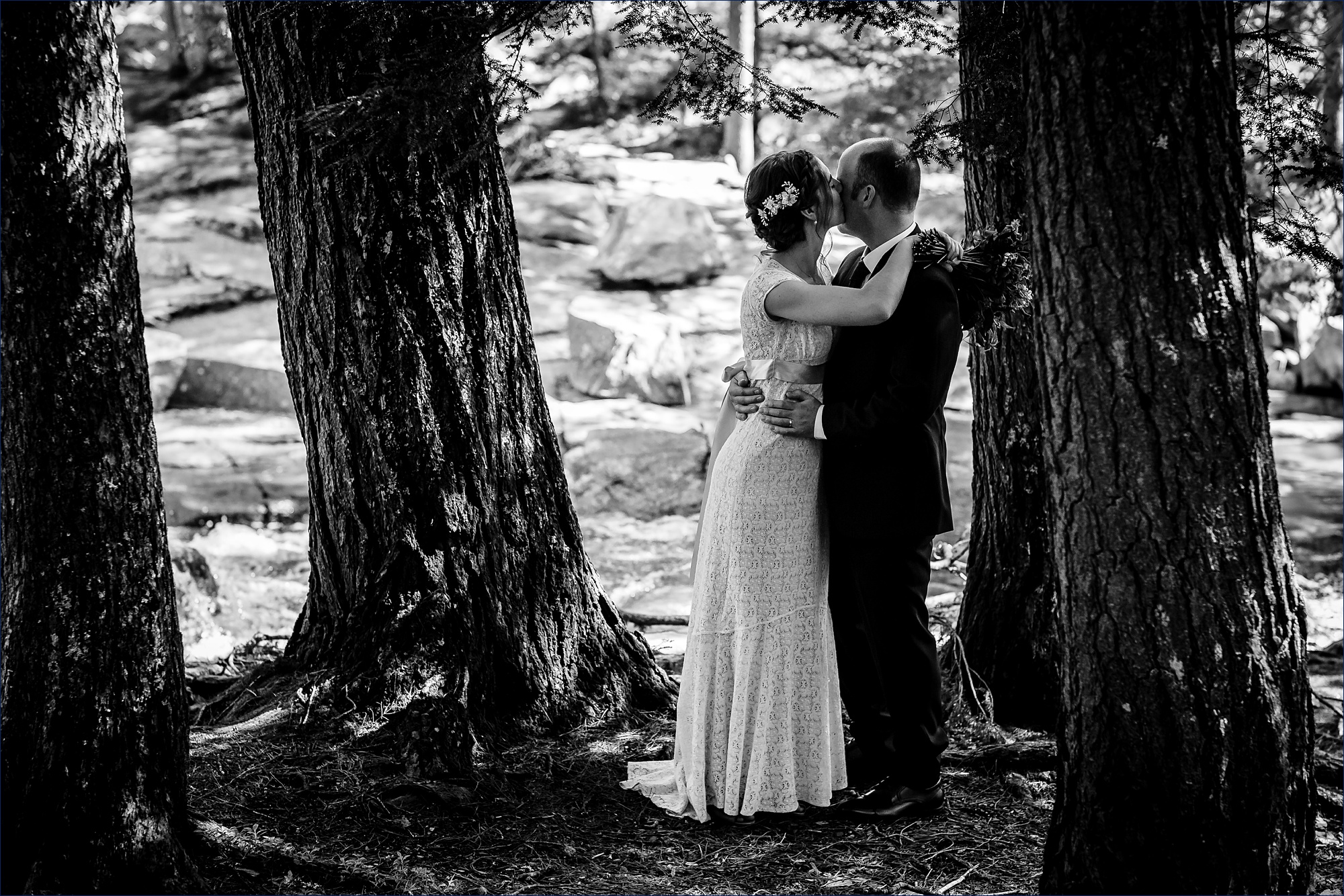 The bride and groom hold each other close by the Jackson Falls in New Hampshire after eloping