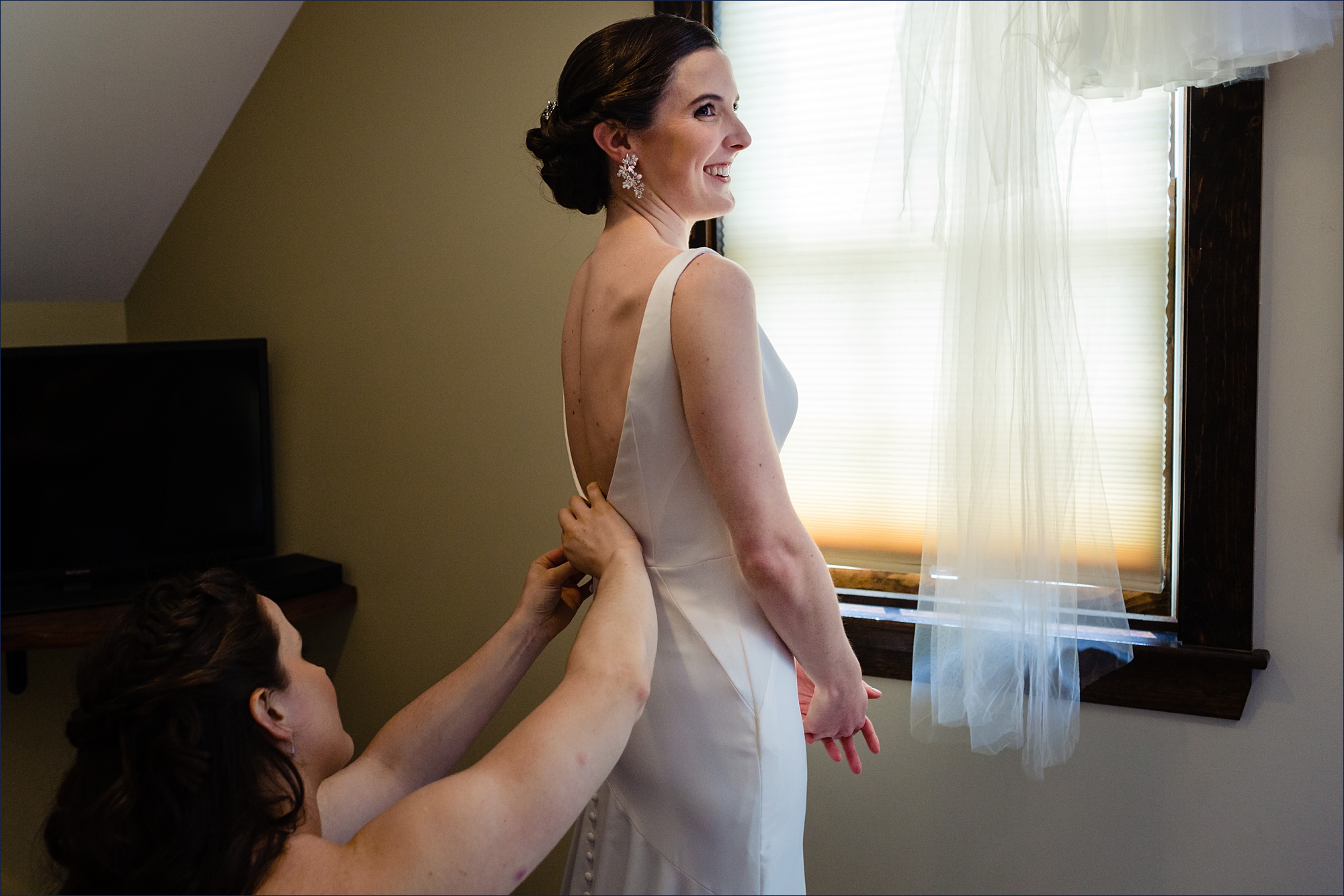 The bride gets into her dress and smiles