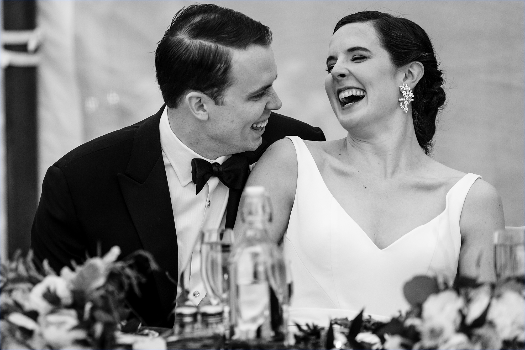 The bride and groom laugh during the toasts at their Maine wedding reception