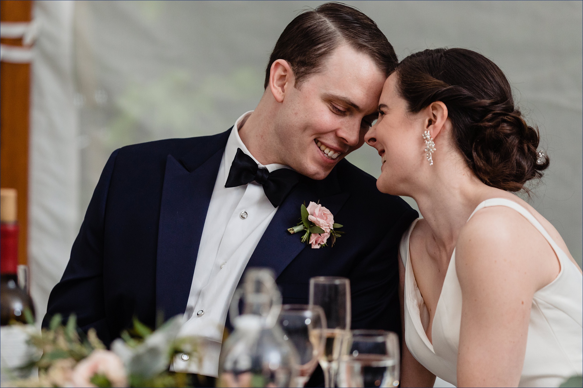 The bride and groom laugh during the toasts at their Maine wedding reception