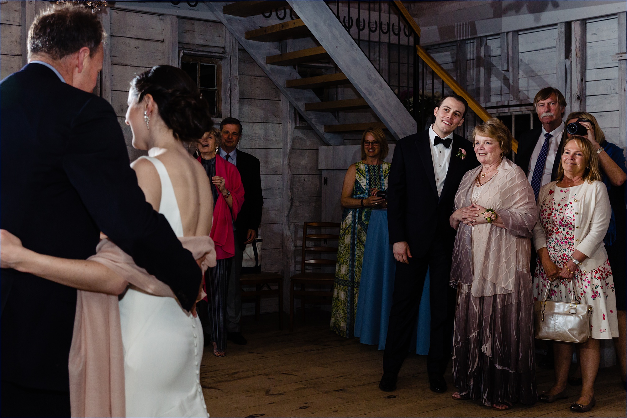 The groom and his mother watch the bride and her father dance at the Maine wedding reception in the Hardy Farm barn