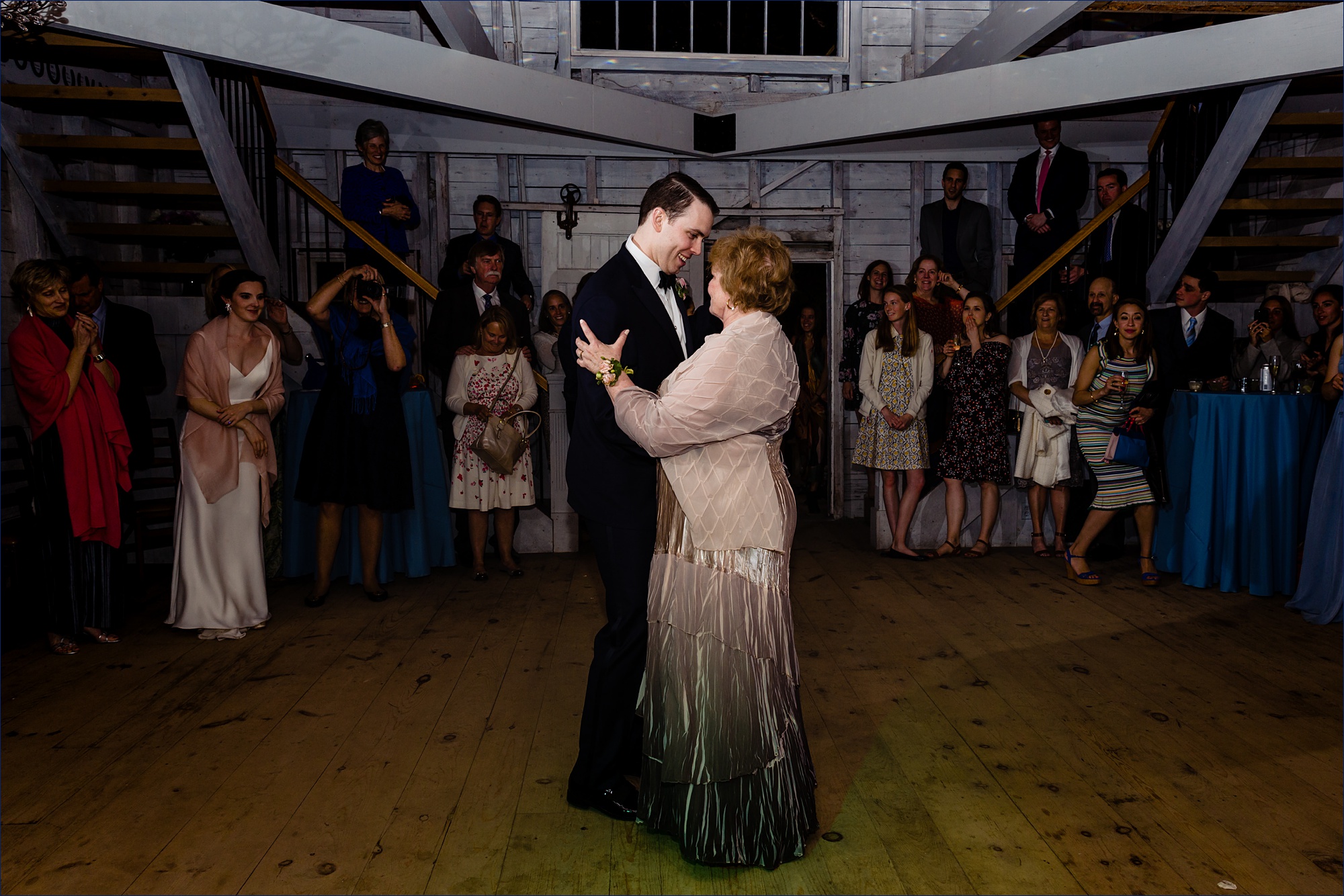 The groom and his mother dance in the barn at his Maine wedding