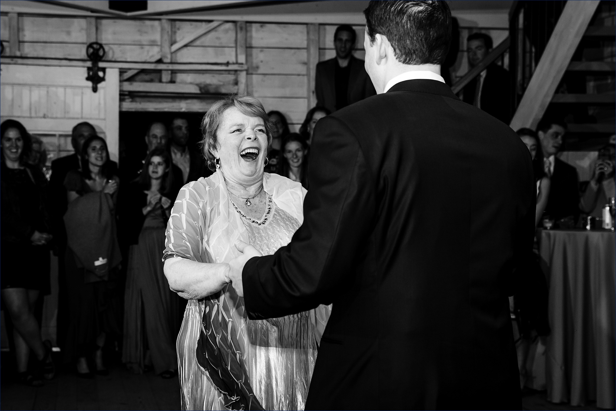 The groom and his mother dance in the barn at his Maine wedding