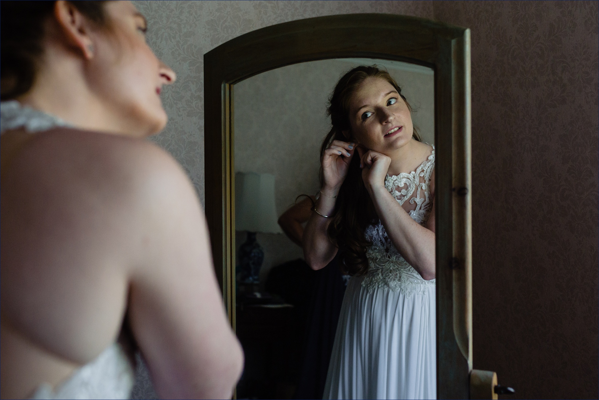 The bride looks into the mirror on her Kitz Farm Wedding day