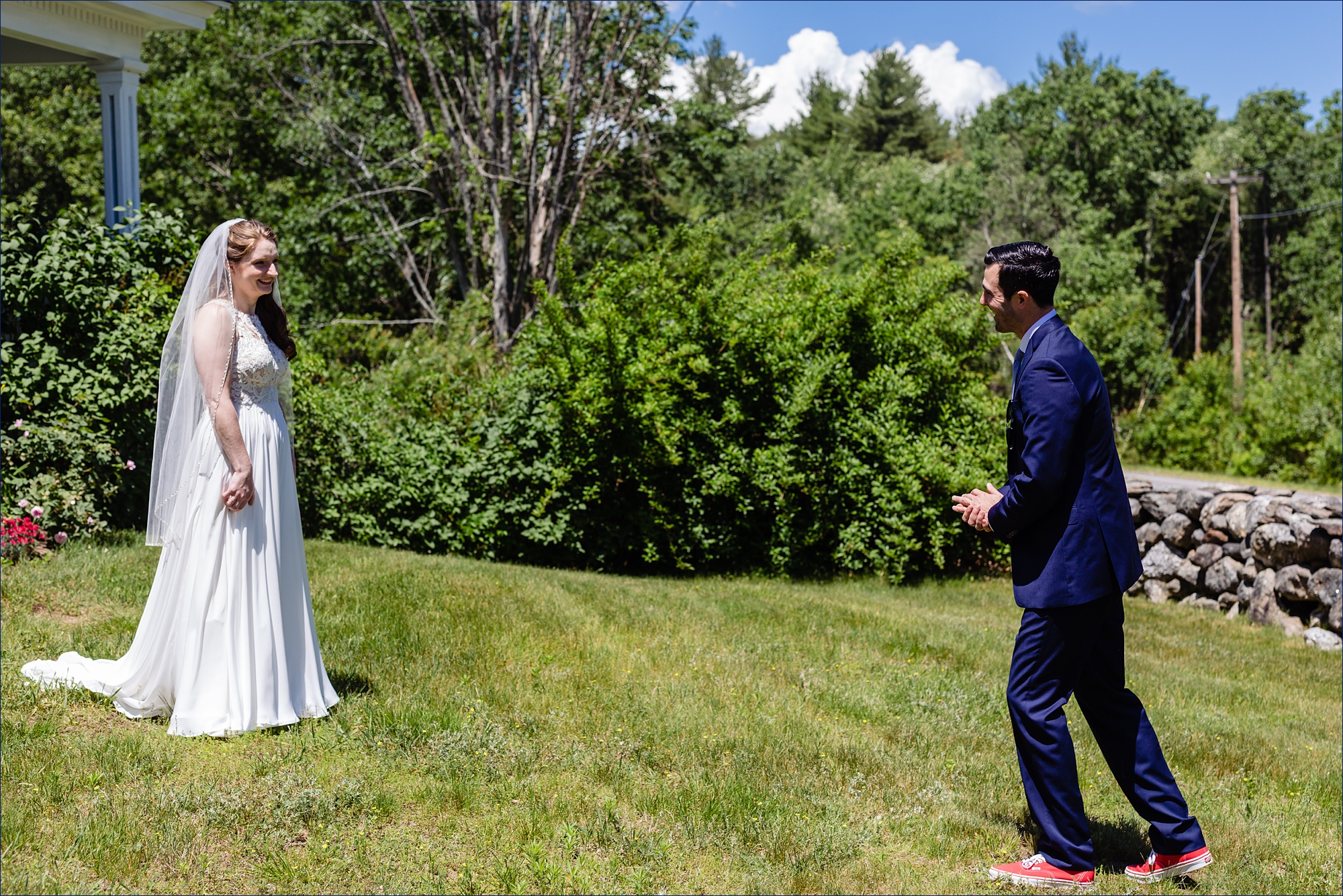 The bride and groom greet each other at their first look on a sunny summer day