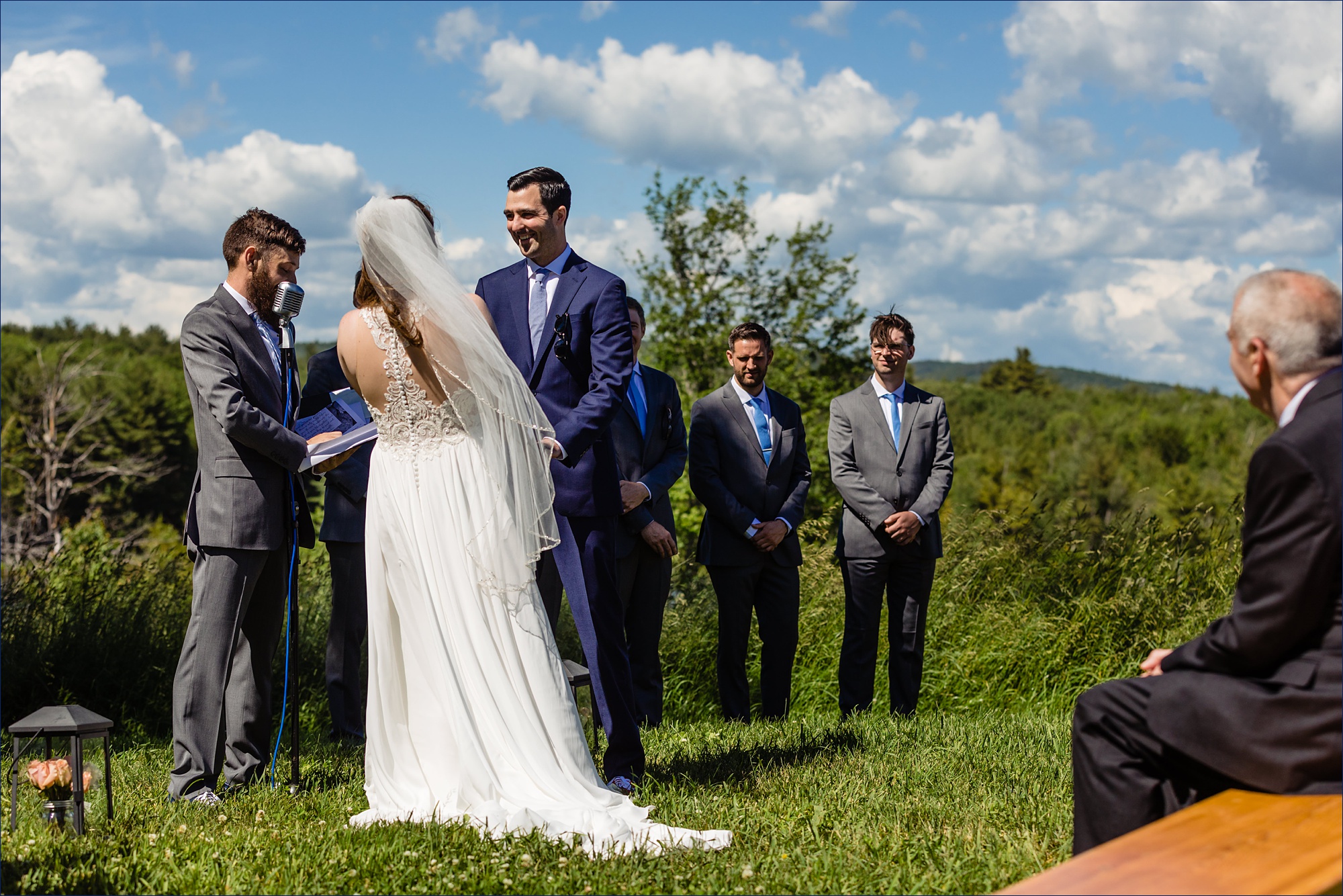 The wedding ceremony at the top of the hill on a sunny summer day with a laughing couple