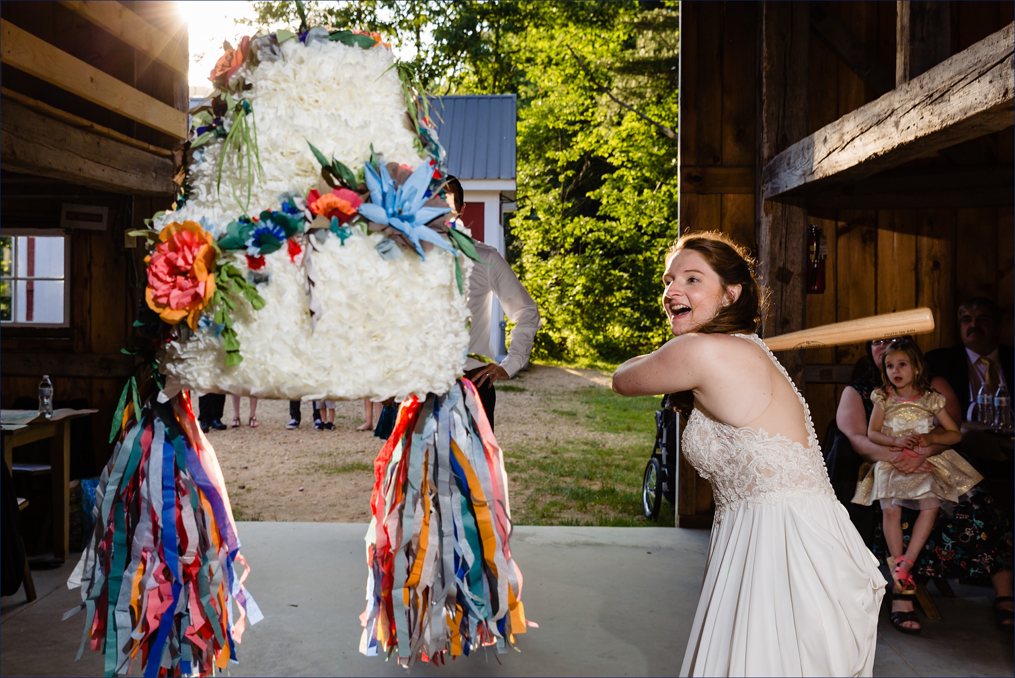 The bride gears up to smash a piñata shaped as a wedding cake 