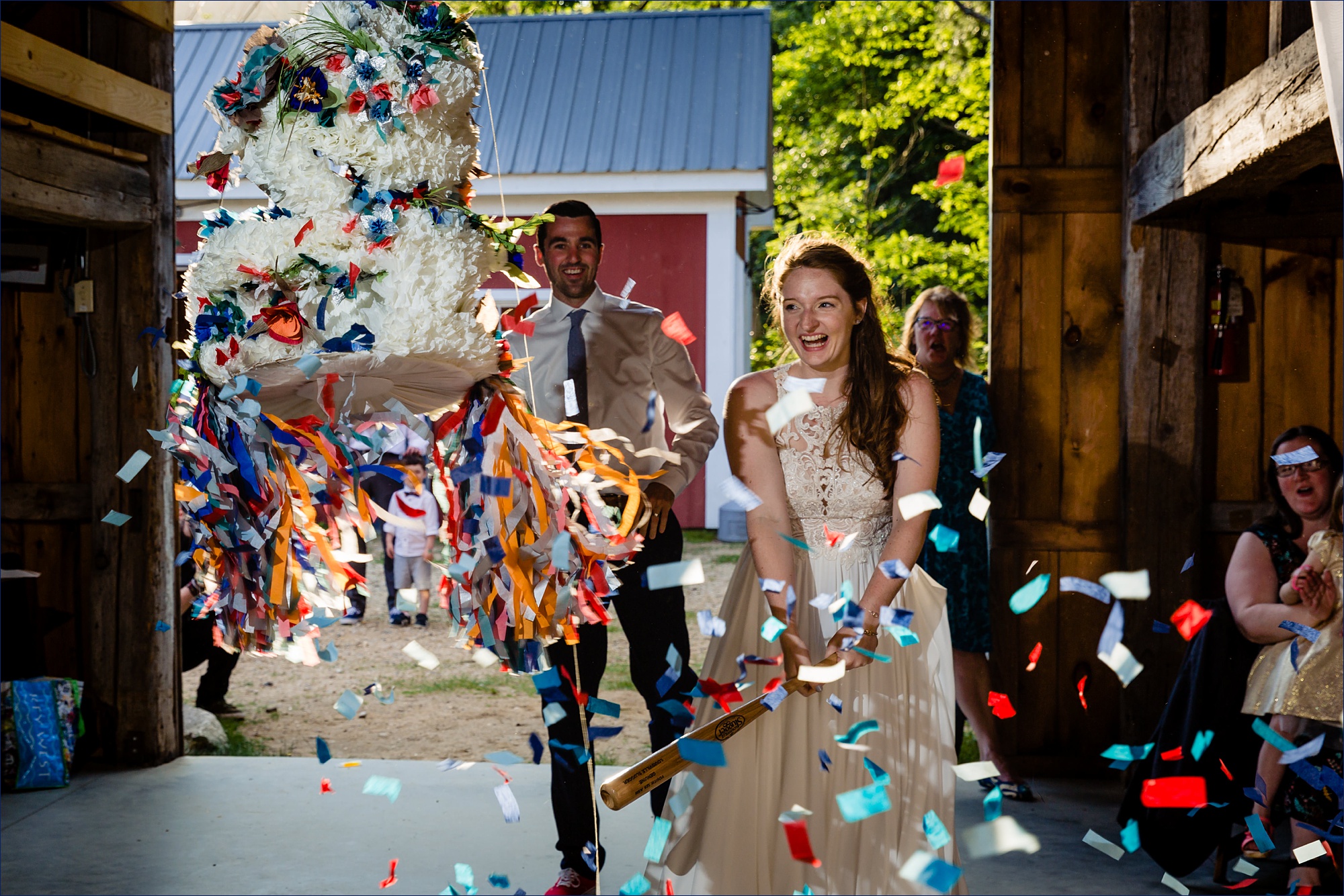The laughs at the falling confetti from the smashed piñata shaped as a wedding cake 