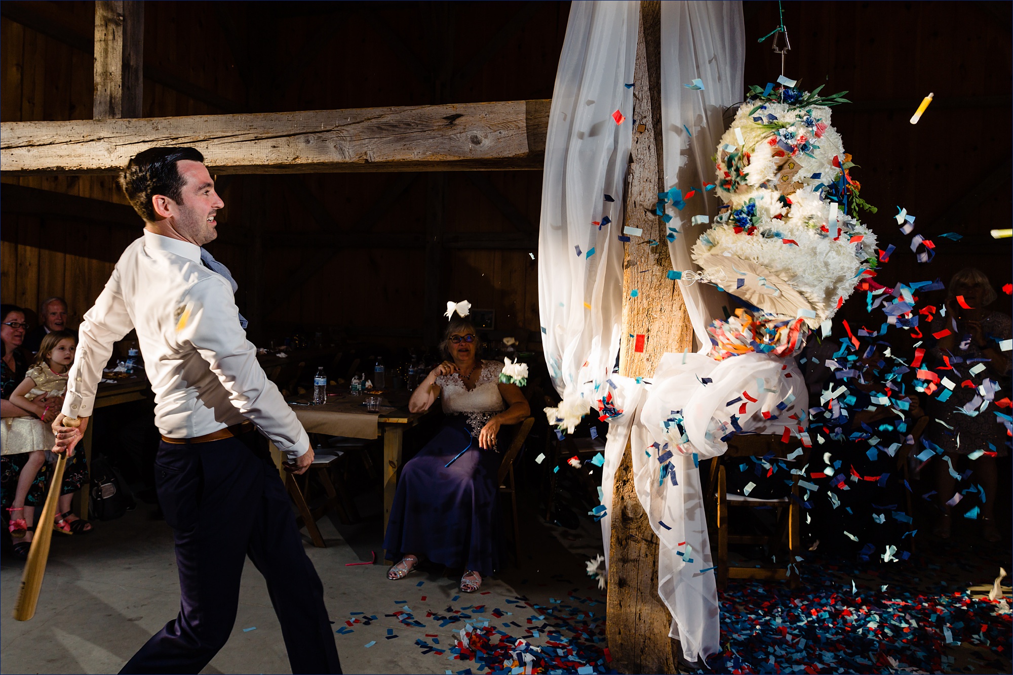 The groom smashes a piñata shaped as a wedding cake 