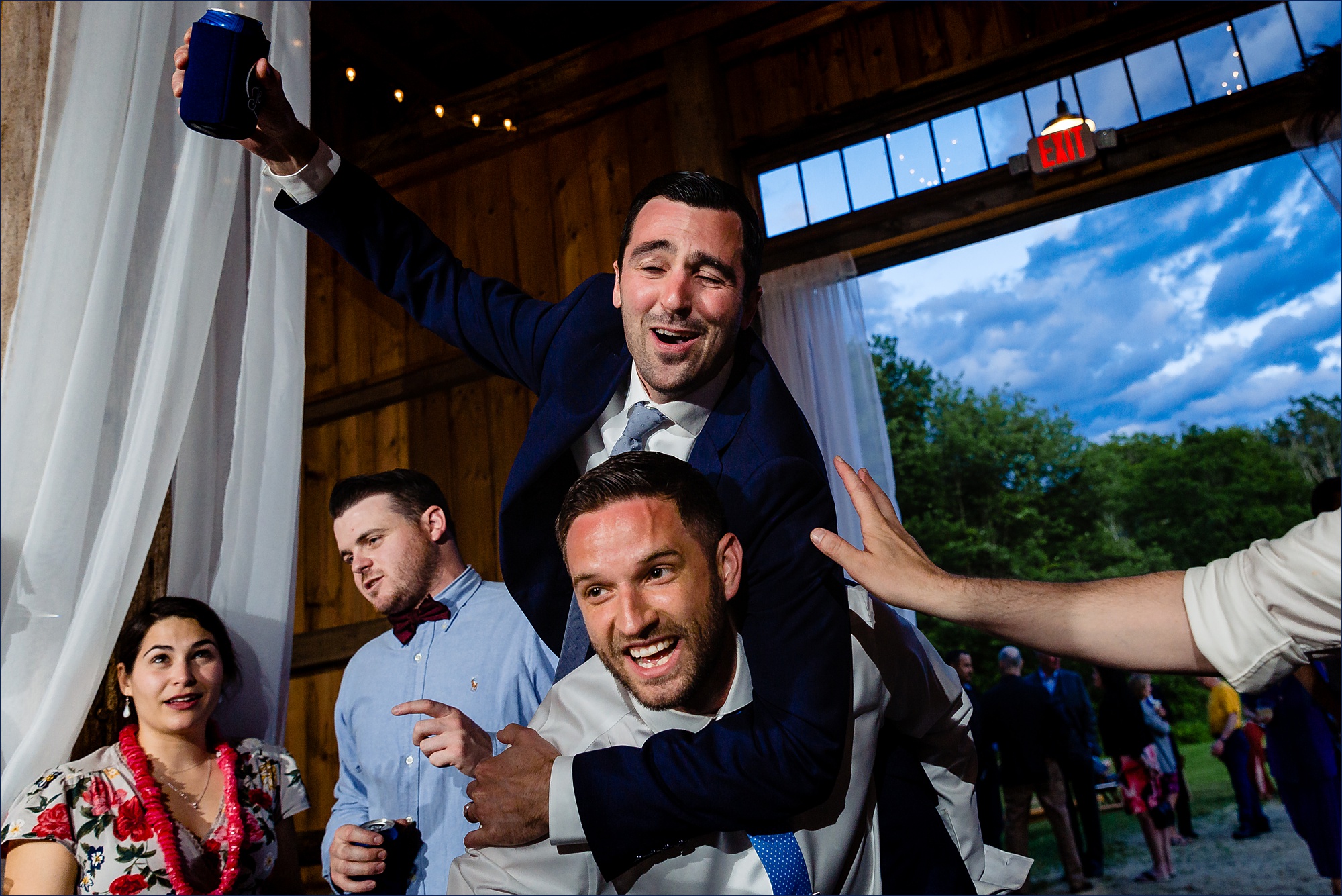 The groom plays chicken on his best friend's back at the wedding reception at Kitz Farm in NH