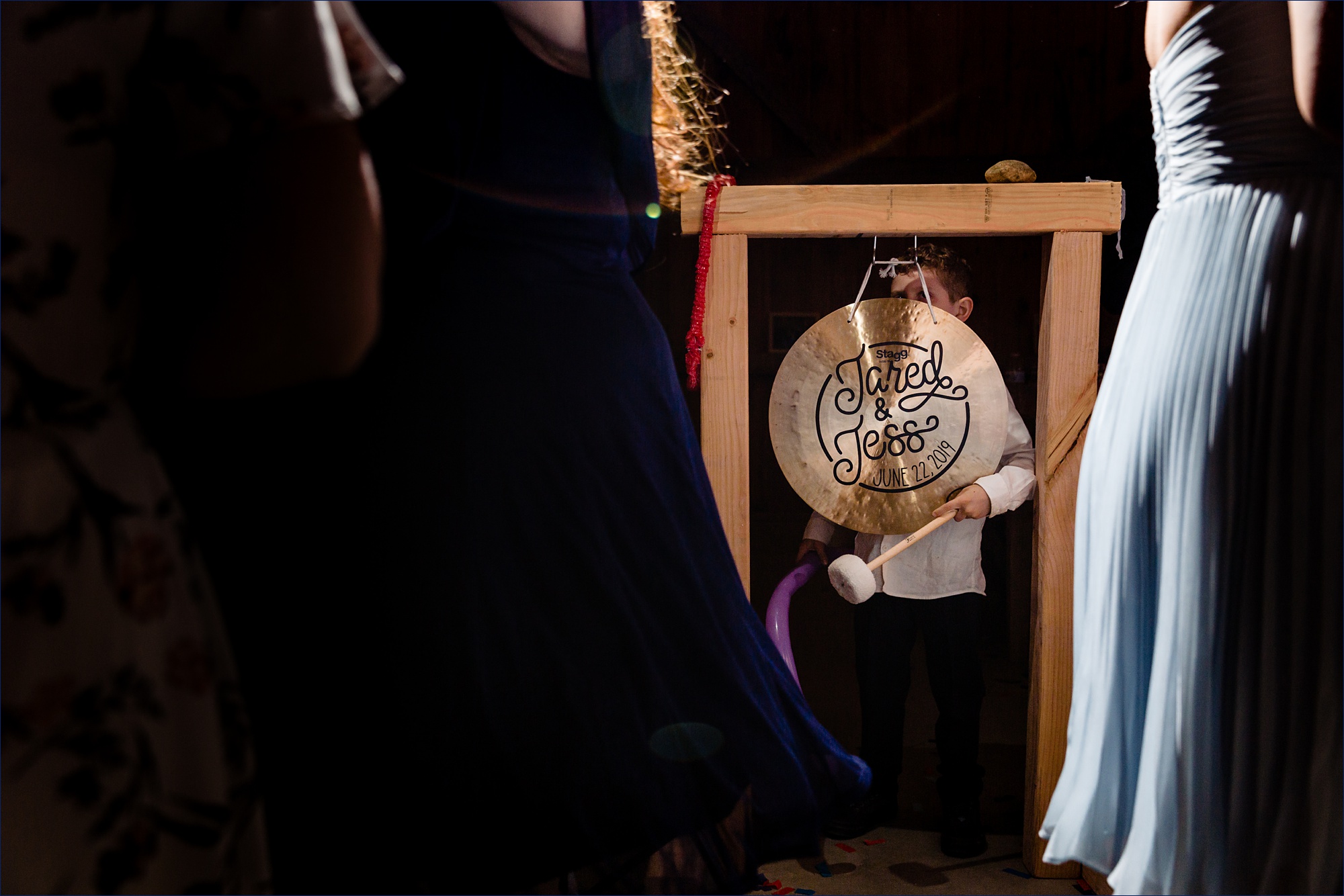 A little boy hits the wedding gong at the barn reception in NH