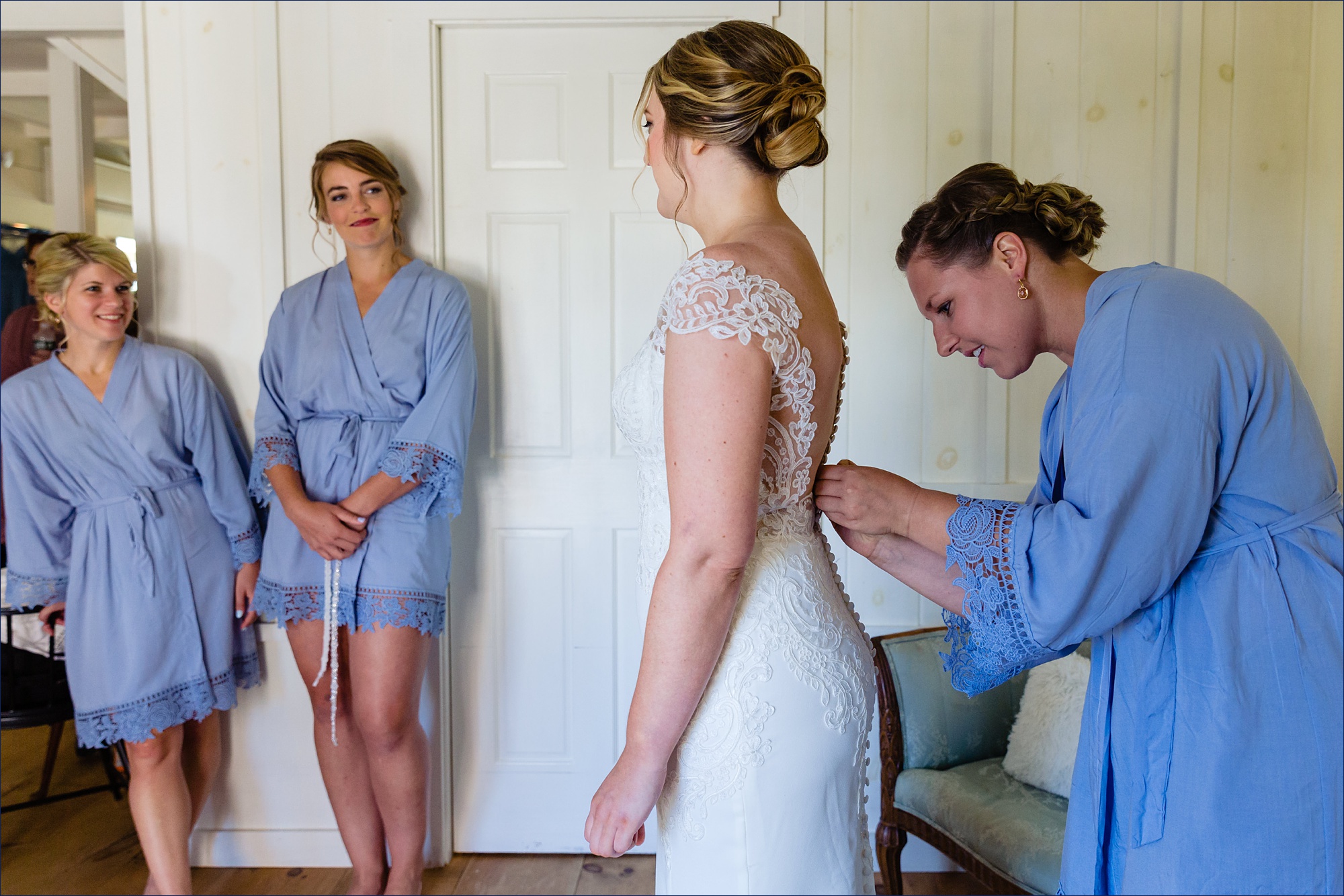 The bridesmaids watch as the bride gets into her wedding gown at The Preserve at Chocorua NH