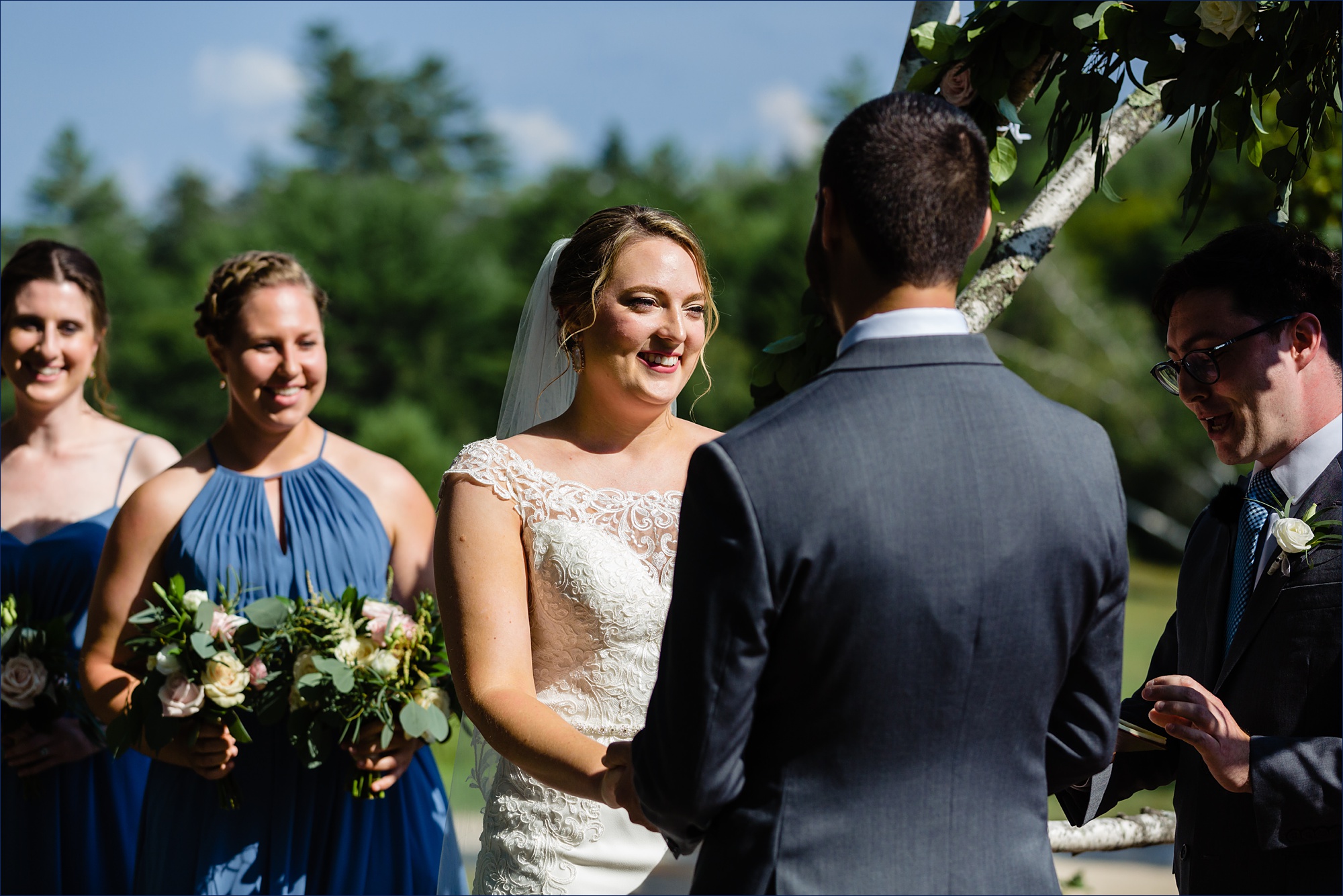 The bride smiles warmly at the groom during their ceremony on the front lawn in New Hampshire