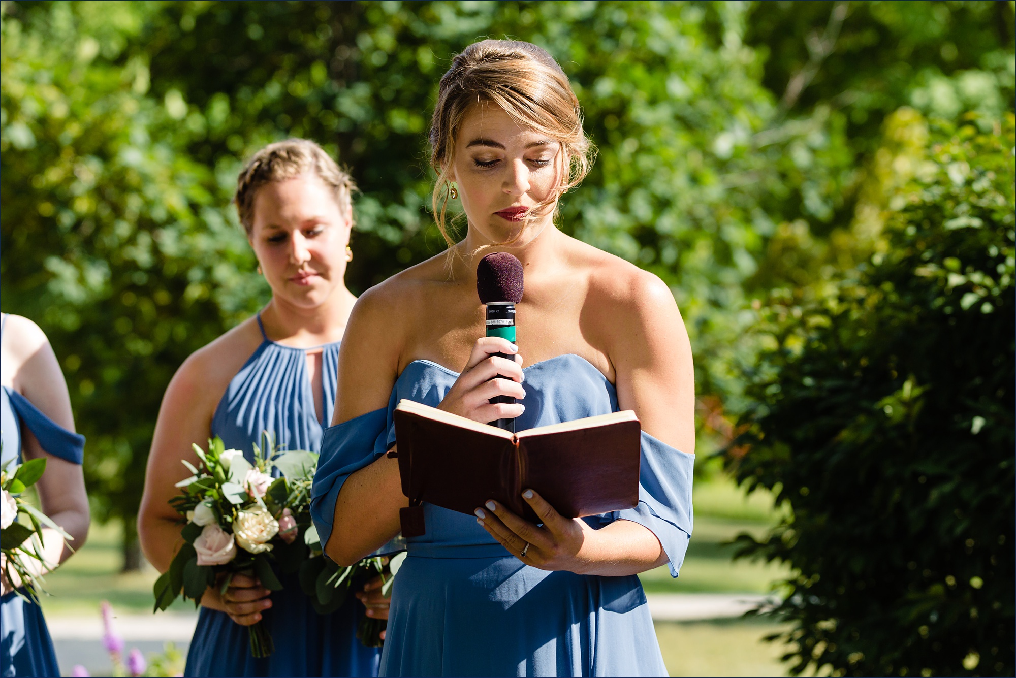Bridesmaid reads a poem during the outdoor ceremony in the summer