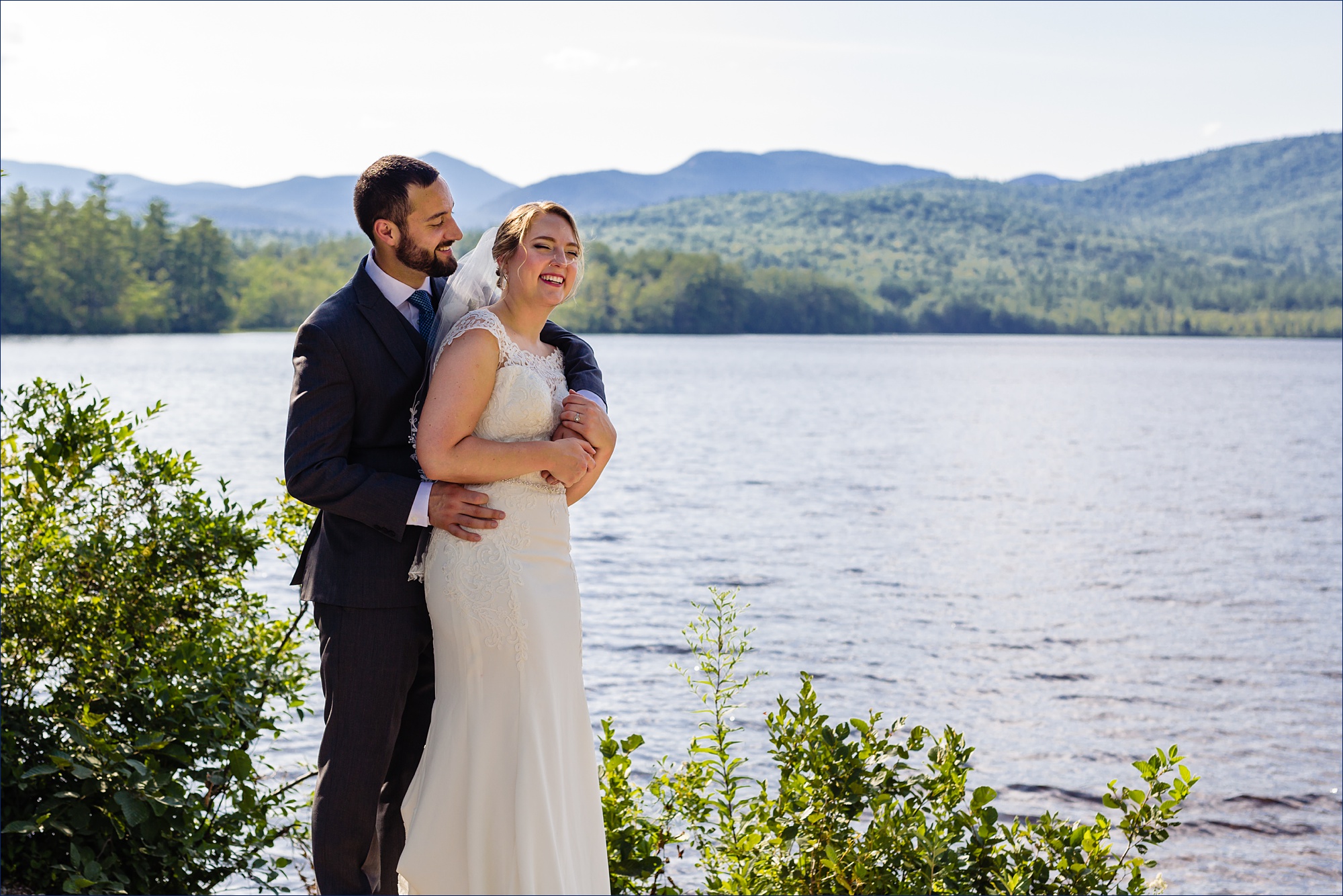 The bride and groom share a laugh after their ceremony in front of Mount Chocorua and Chocorua Lake in New Hampshire