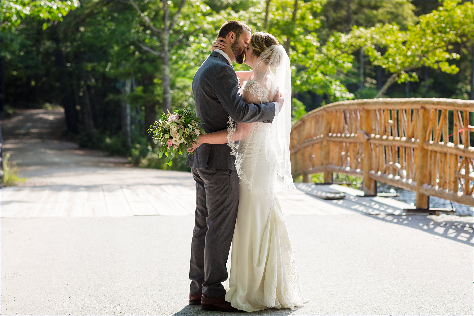 The newlyweds share a romantic kiss on the bridge over Lake Chocorua at their New Hampshire wedding day