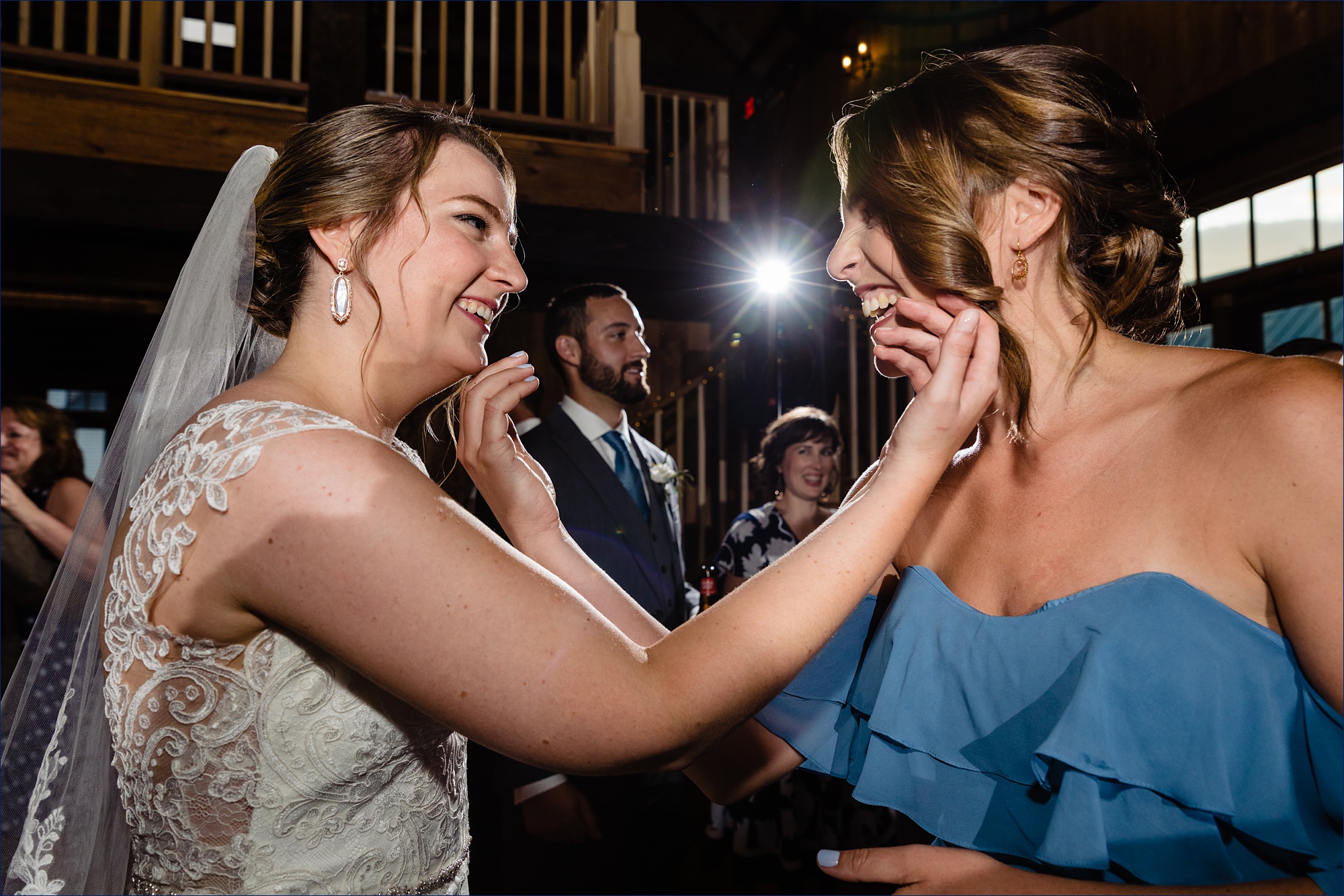 The bride shares a moment with her bridesmaid at the barn at the Preserve at Chocorua wedding reception