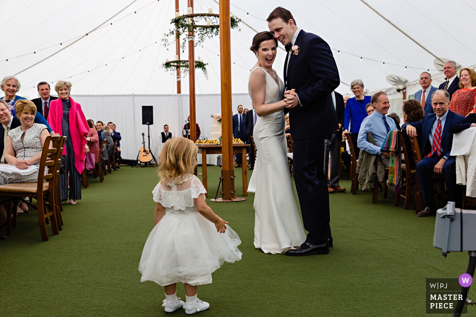 Award winning Hardy Farm Wedding Photographer capturing the bride and groom laughing at the flower girl during their first dance at their Maine wedding