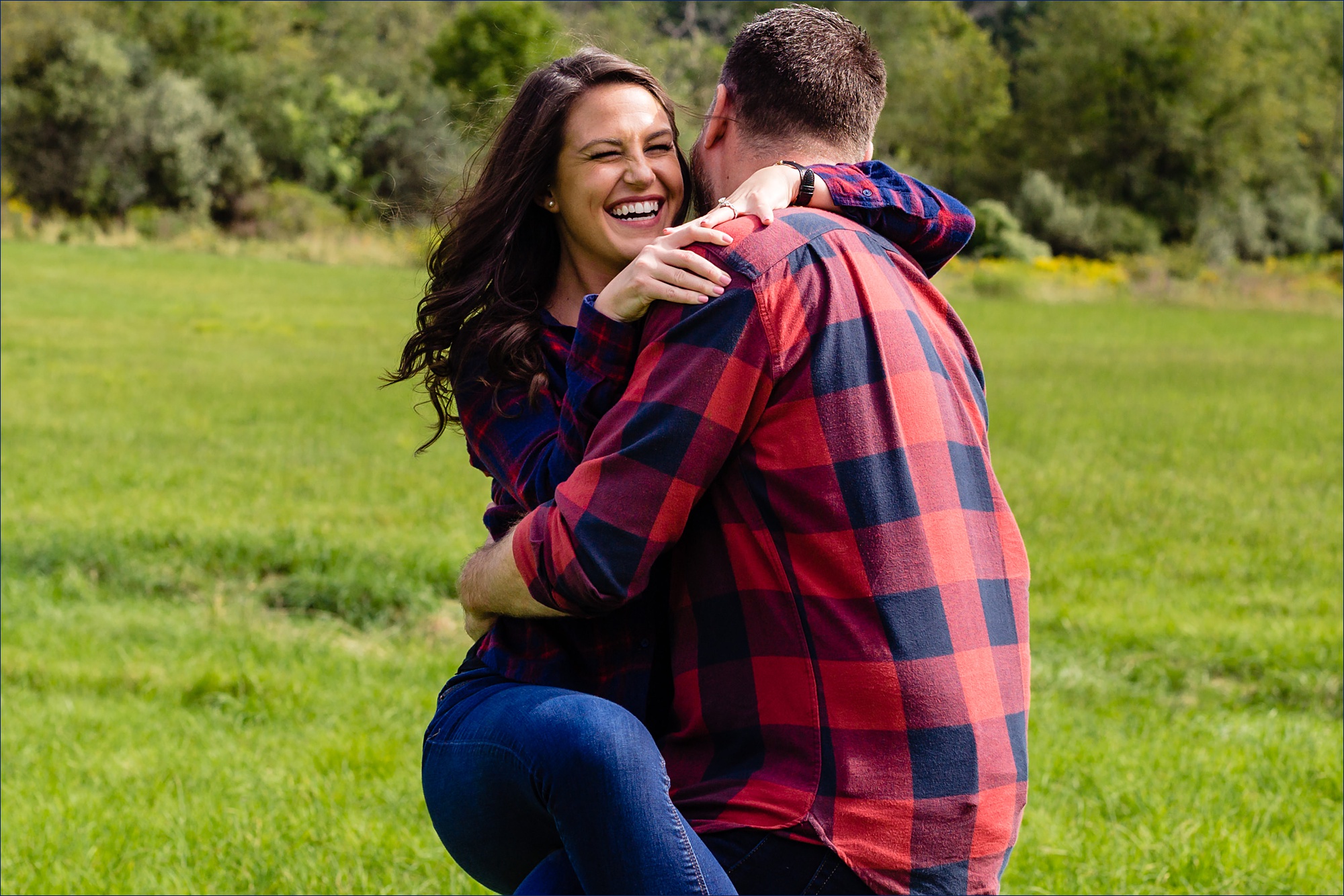 She laughs as he picks her up at their NH engagement session