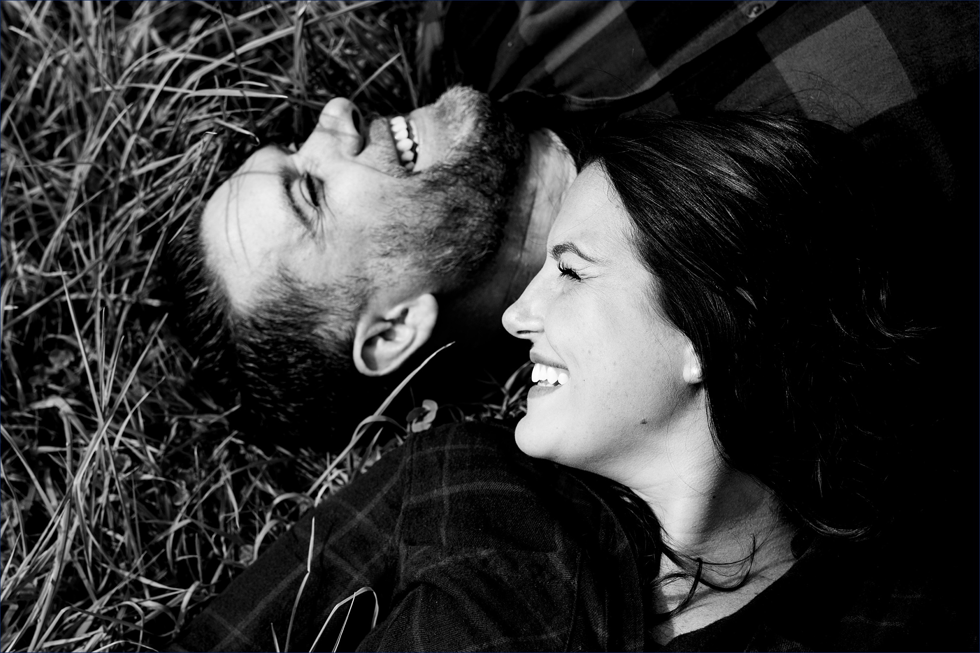 Laying in the grass for their engagement session in Dover NH