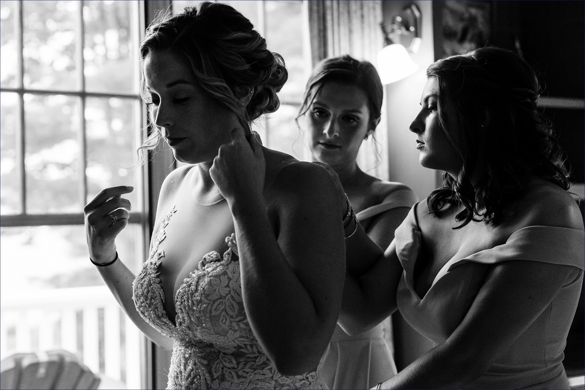 The bride gets some help from her bridesmaids as she puts on her dress