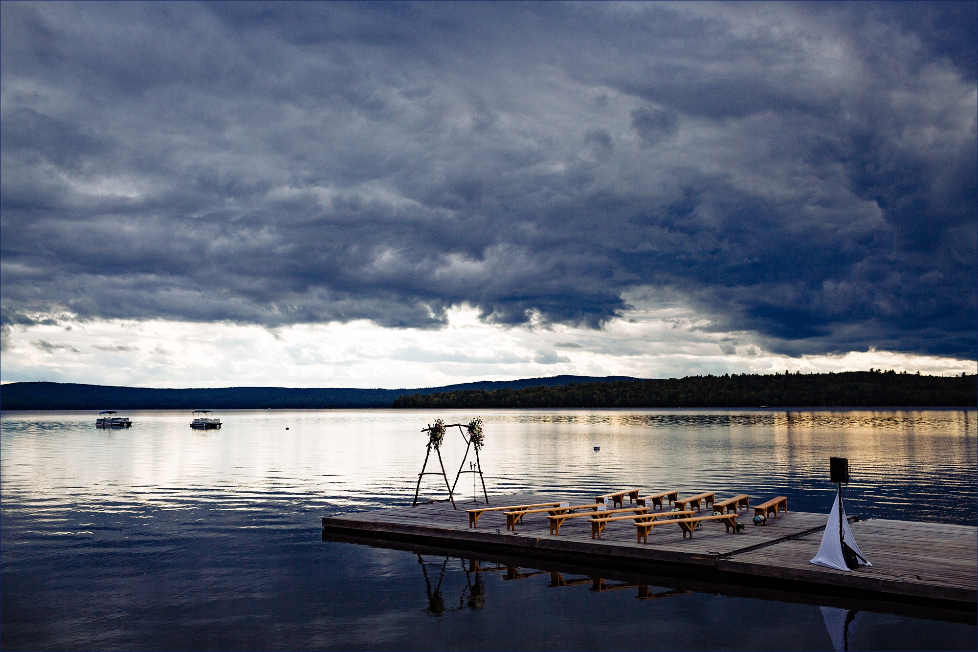 The ceremony space out on a dock overlooking a Maine's Mooselookmeguntic Lake and the mountains on a stormy day