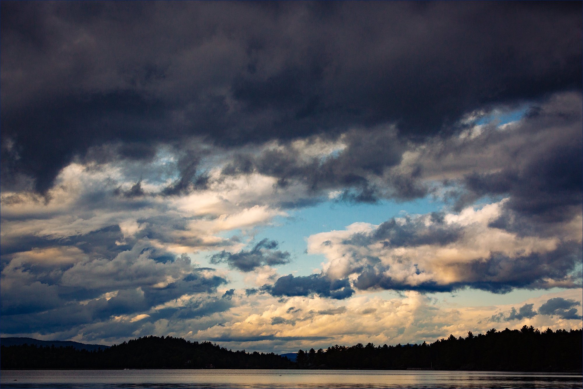 The stormy skies over Mooselookmeguntic Lake and mountains on the Maine wedding day