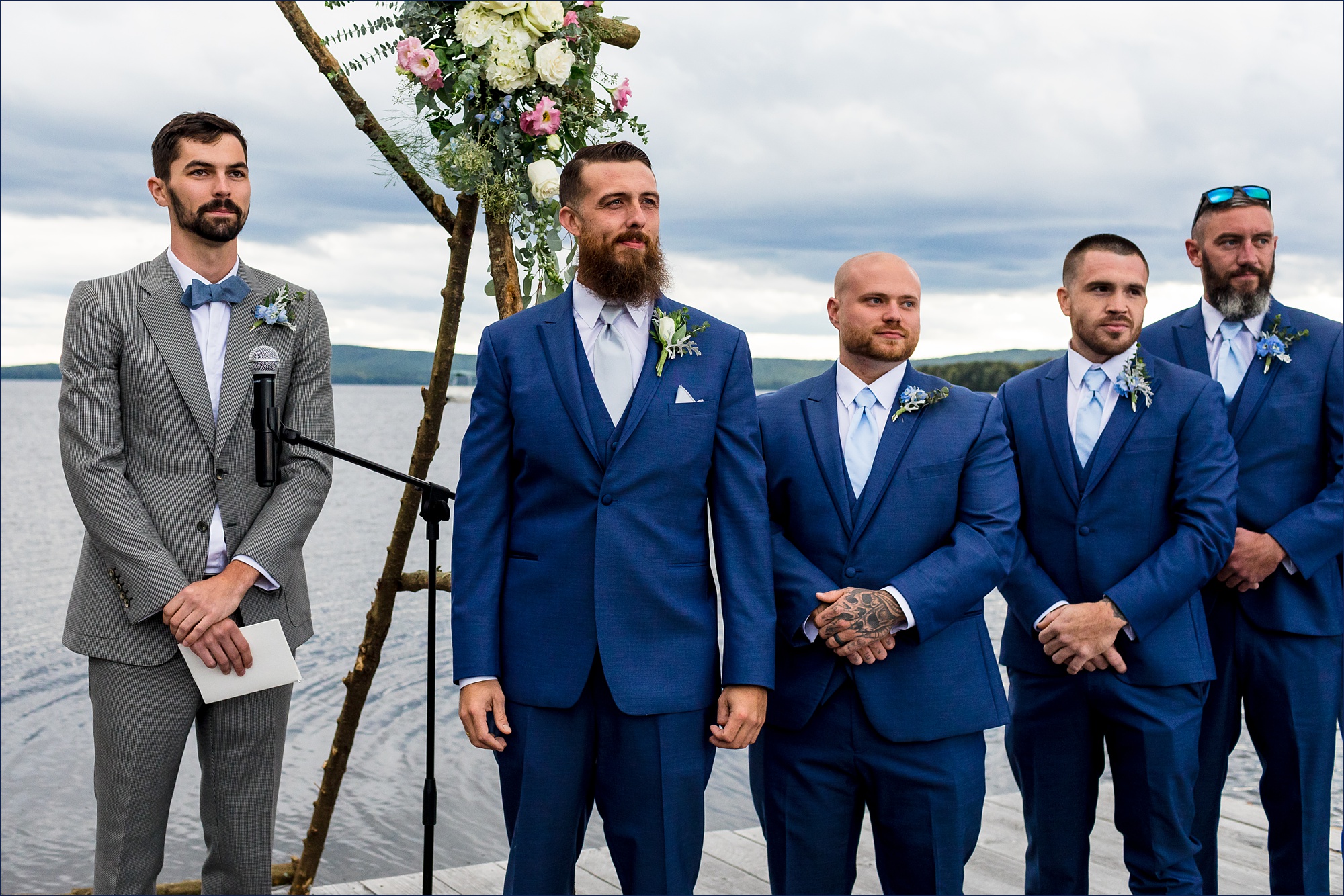 The groom watches as the bride comes down the aisle of the dock ceremony