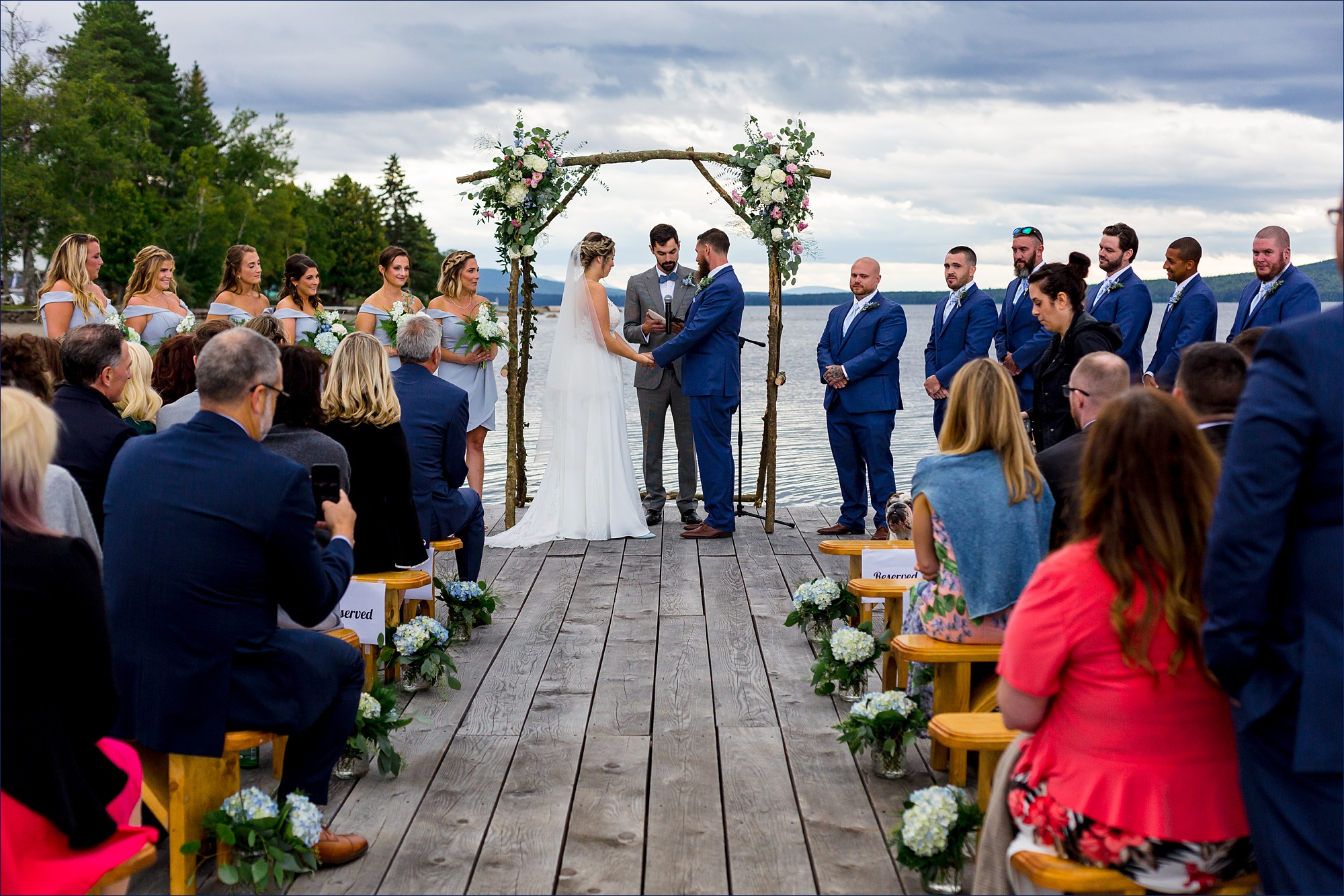 The bride and groom have a ceremony out on a dock for their Maine wedding day